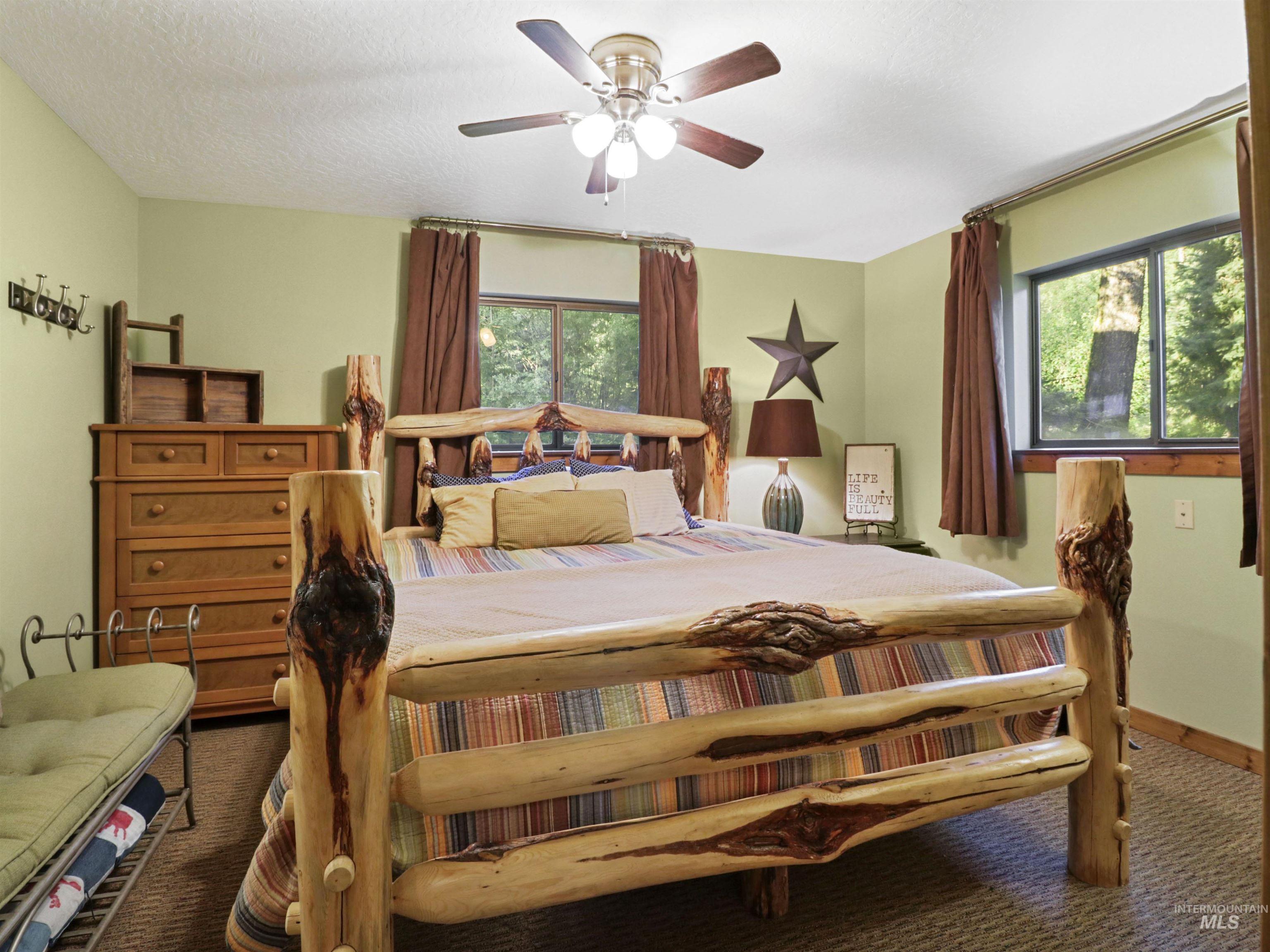 Carpeted bedroom featuring ceiling fan and a textured ceiling