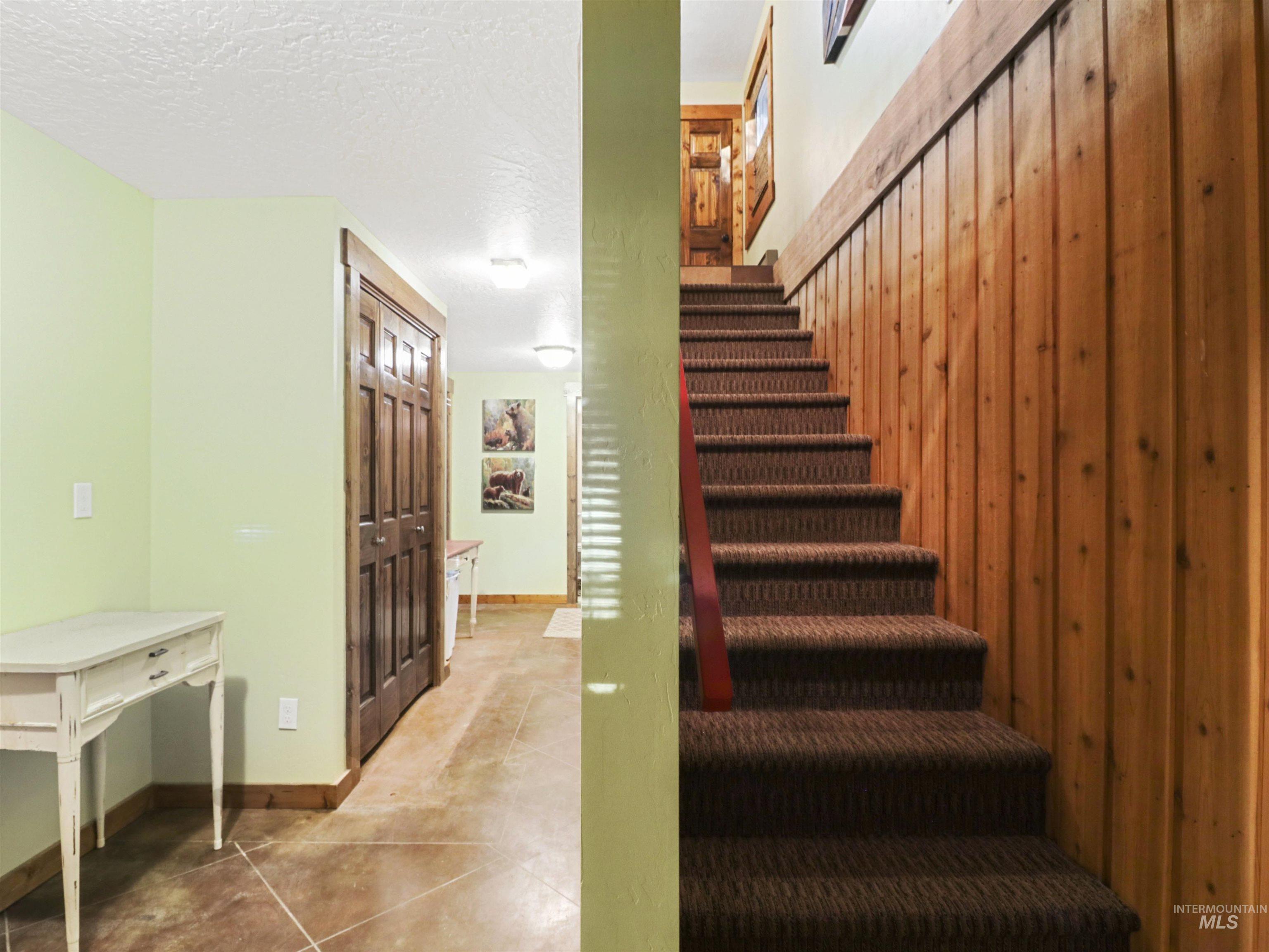 Stairs featuring a textured ceiling and tile patterned floors
