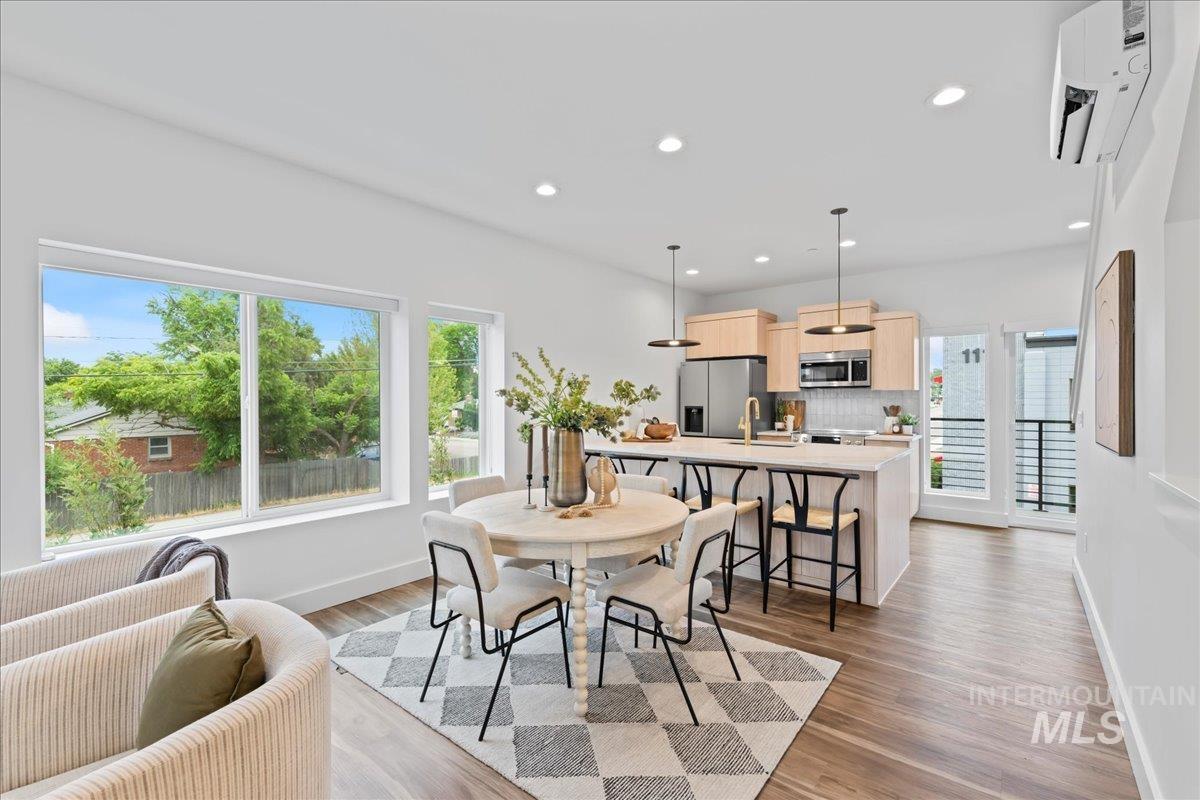 Showing unit 101 with light cabinet option. Dining space with recessed lighting, dark LVP floors.