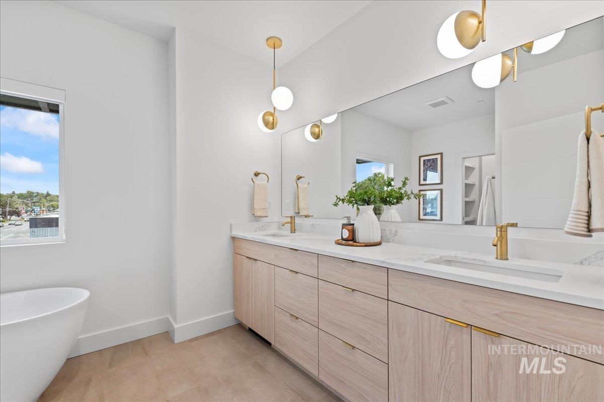 Bathroom featuring double vanity and a freestanding tub