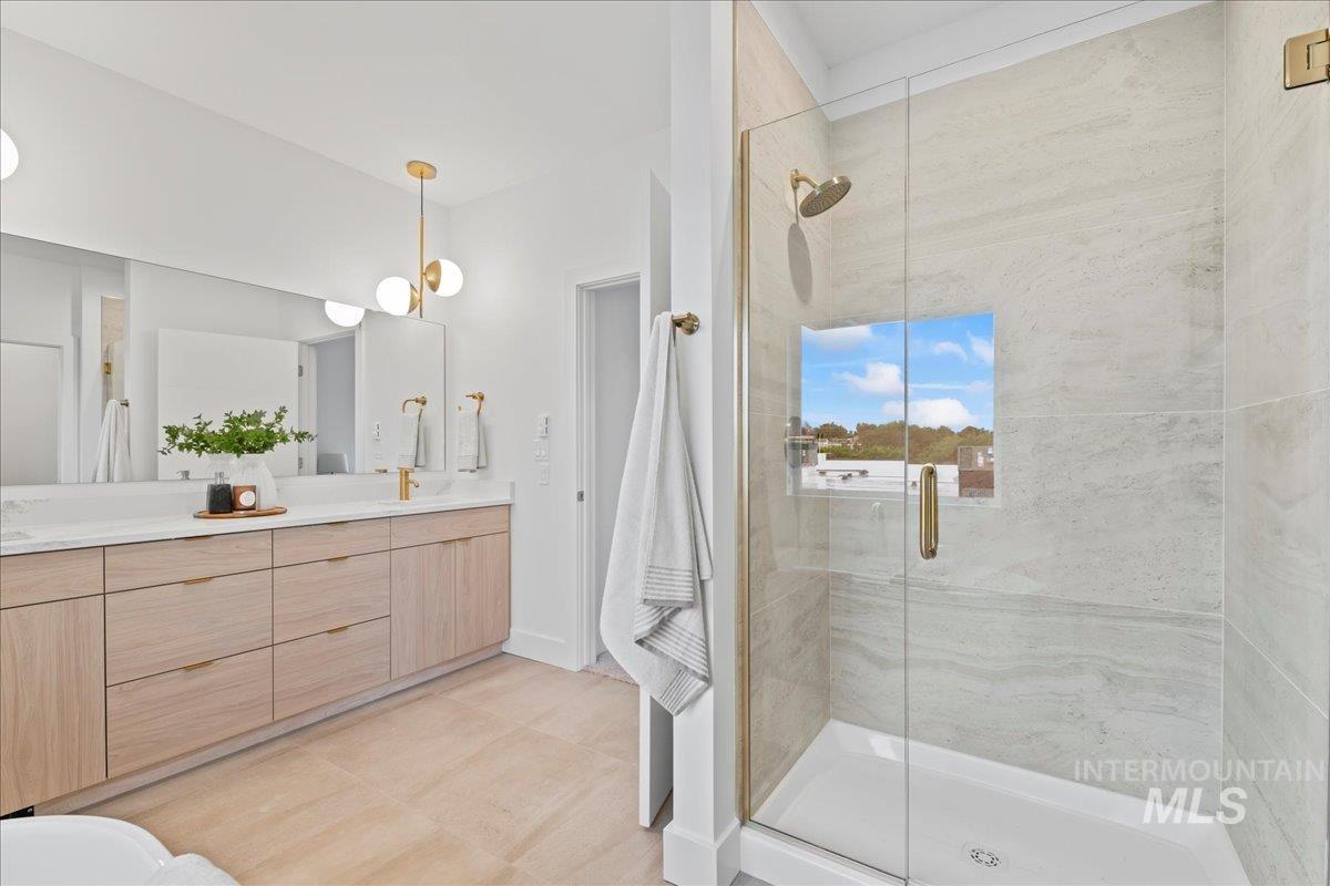Full bathroom with double vanity and a stall shower