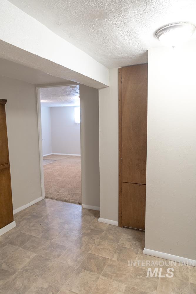 Below grade area with baseboards and a textured ceiling