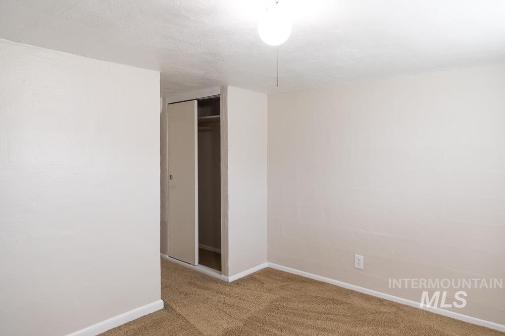 Unfurnished bedroom with carpet, a closet, and a textured ceiling