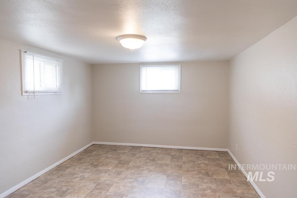 Empty room featuring stone finish floors and a textured ceiling