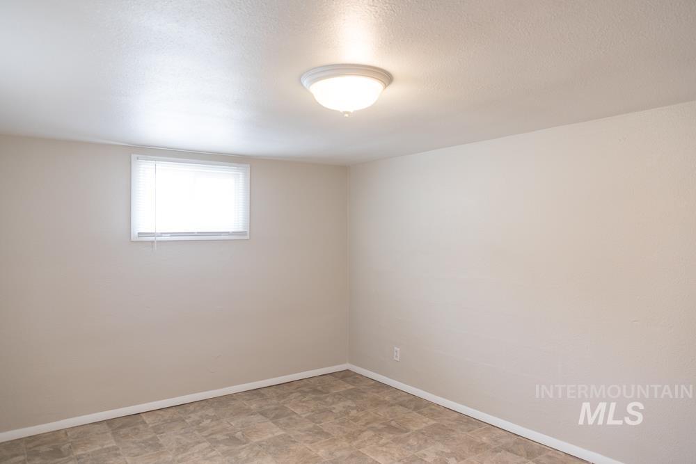 Empty room featuring a textured ceiling and stone finish flooring