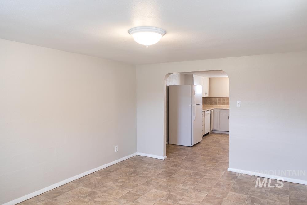 Empty room featuring arched walkways and stone finish floors