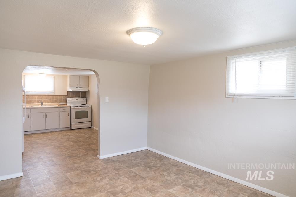 Empty room featuring arched walkways and baseboards