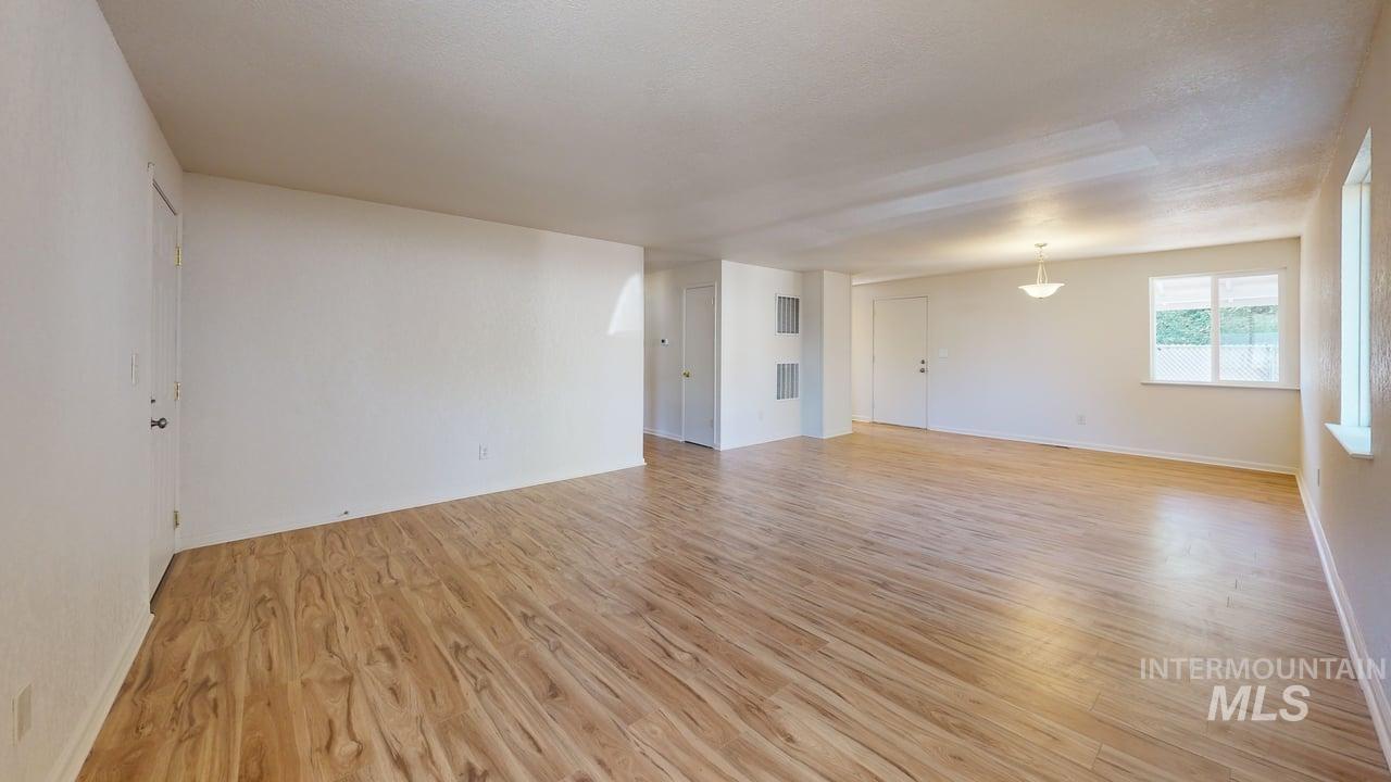 Empty room featuring light wood finished floors and baseboards