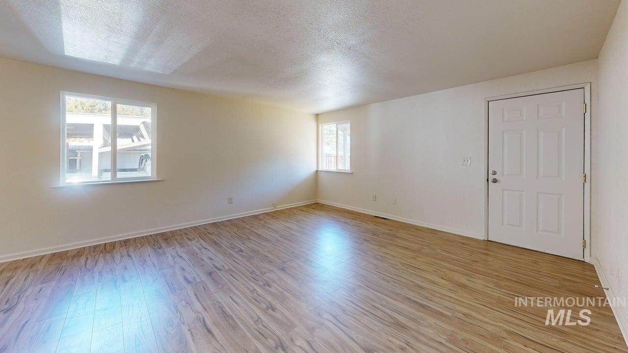 Spare room with a textured ceiling and light wood-type flooring