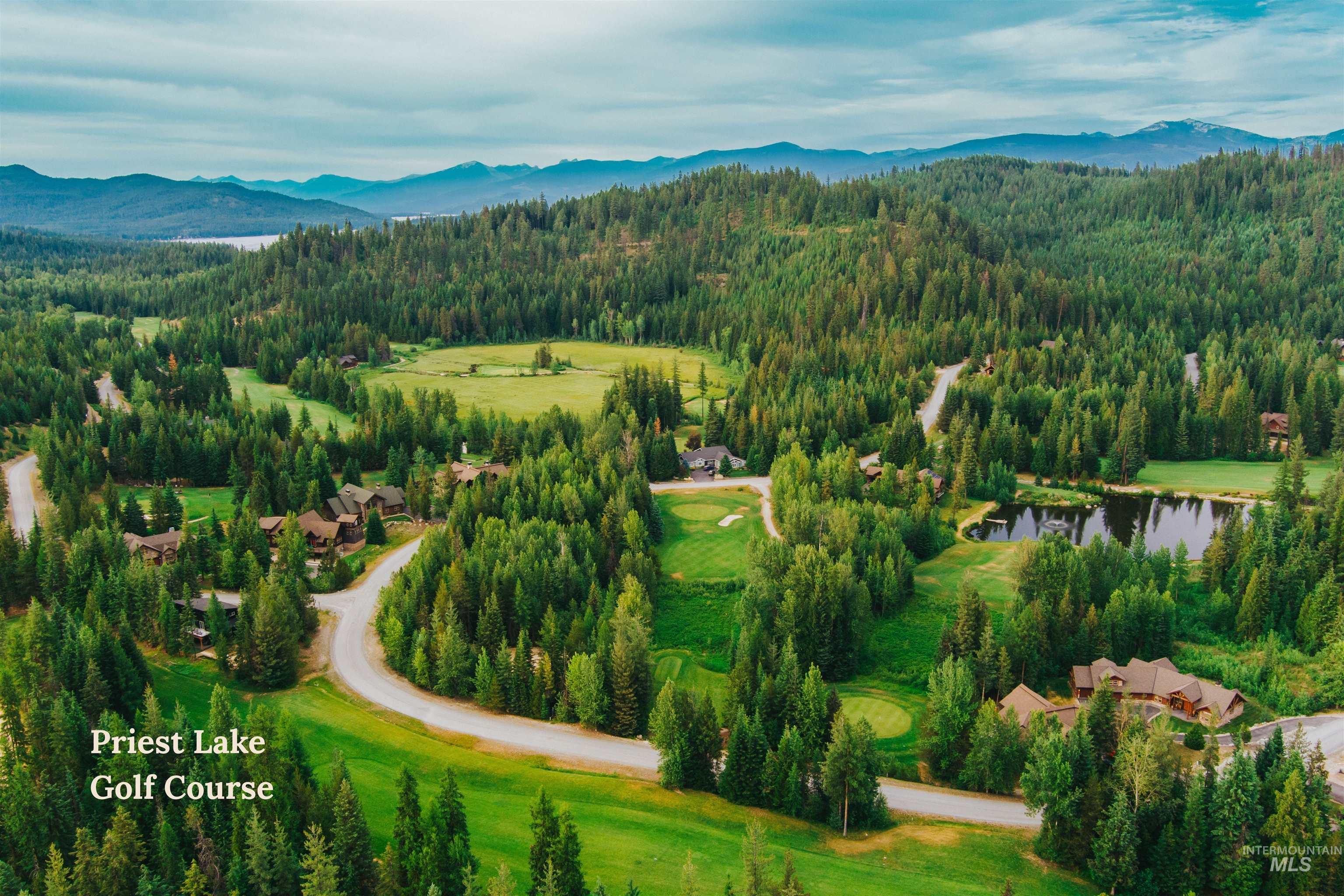 Drone / aerial view of a water and mountain view and a local golf course