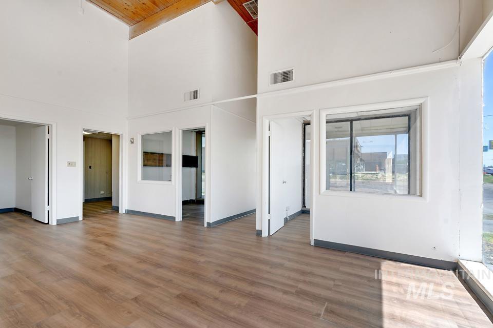 Unfurnished living room featuring high vaulted ceiling and wood finished floors