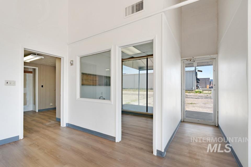 Spare room with wood finished floors and a towering ceiling