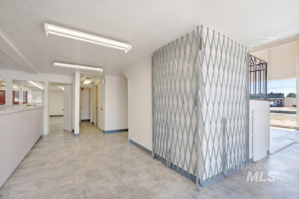 Hallway featuring a textured ceiling and baseboards