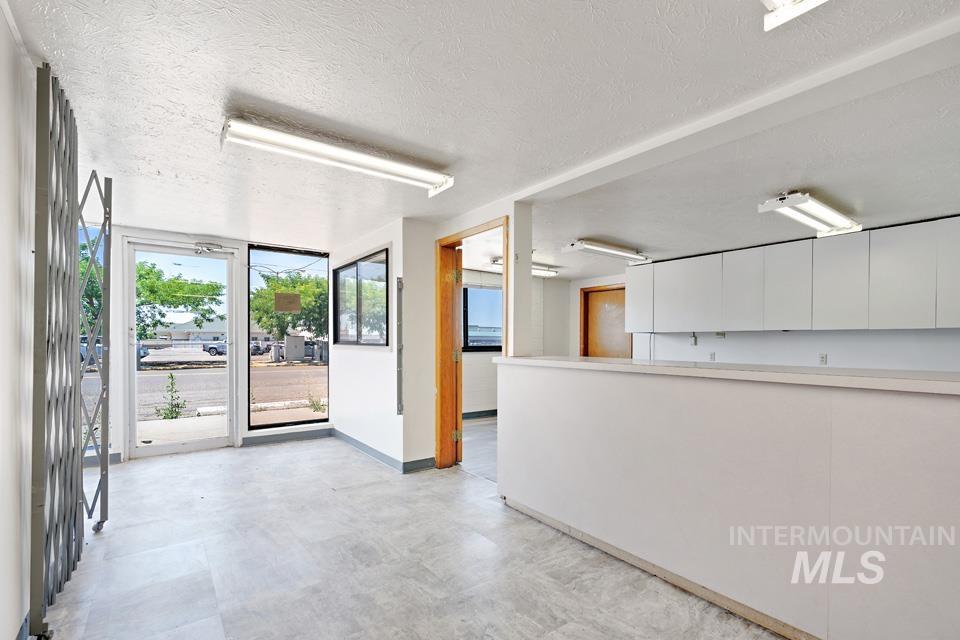 Empty room with a textured ceiling and concrete flooring