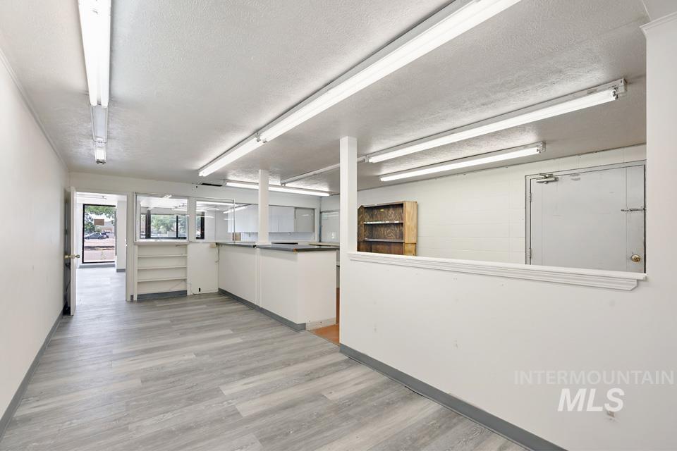 Unfurnished room featuring light wood finished floors and a textured ceiling
