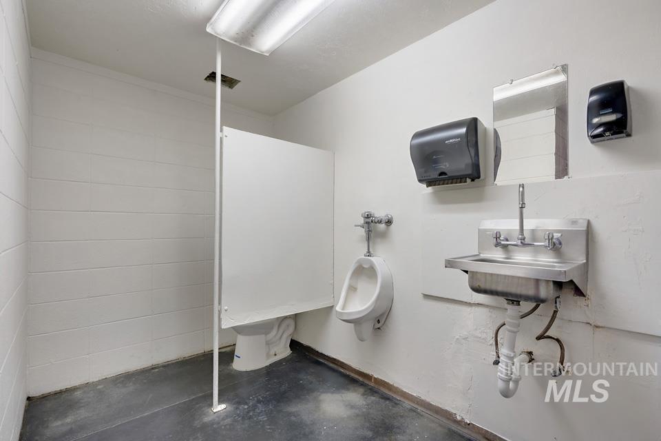 Bathroom with concrete floors and concrete block wall