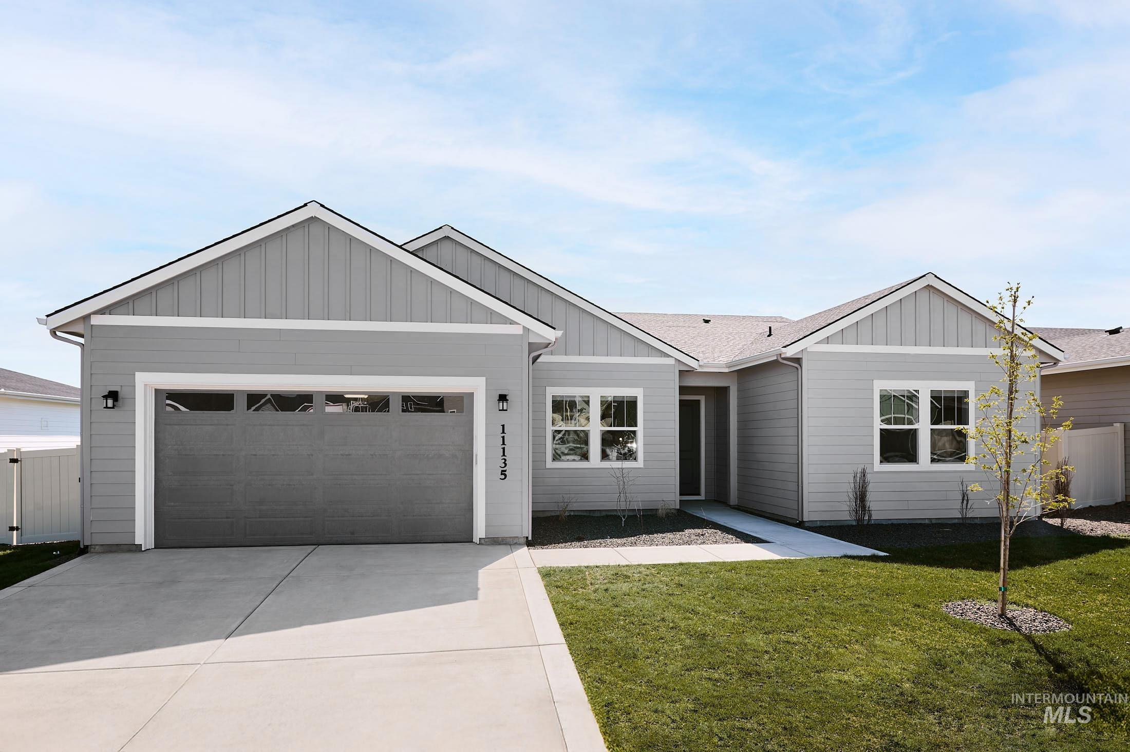 Ranch-style home with concrete driveway, an attached garage, board and batten siding, and a shingled roof