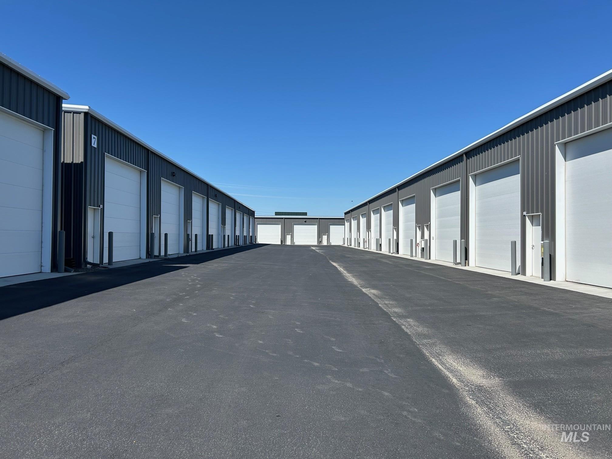 View of asphalt road featuring community garages