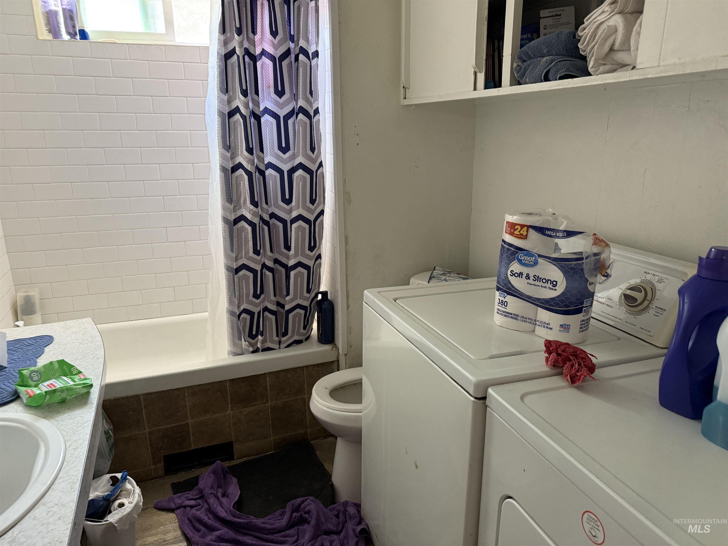 Full bath featuring independent washer and dryer, tiled shower / bath, and vanity