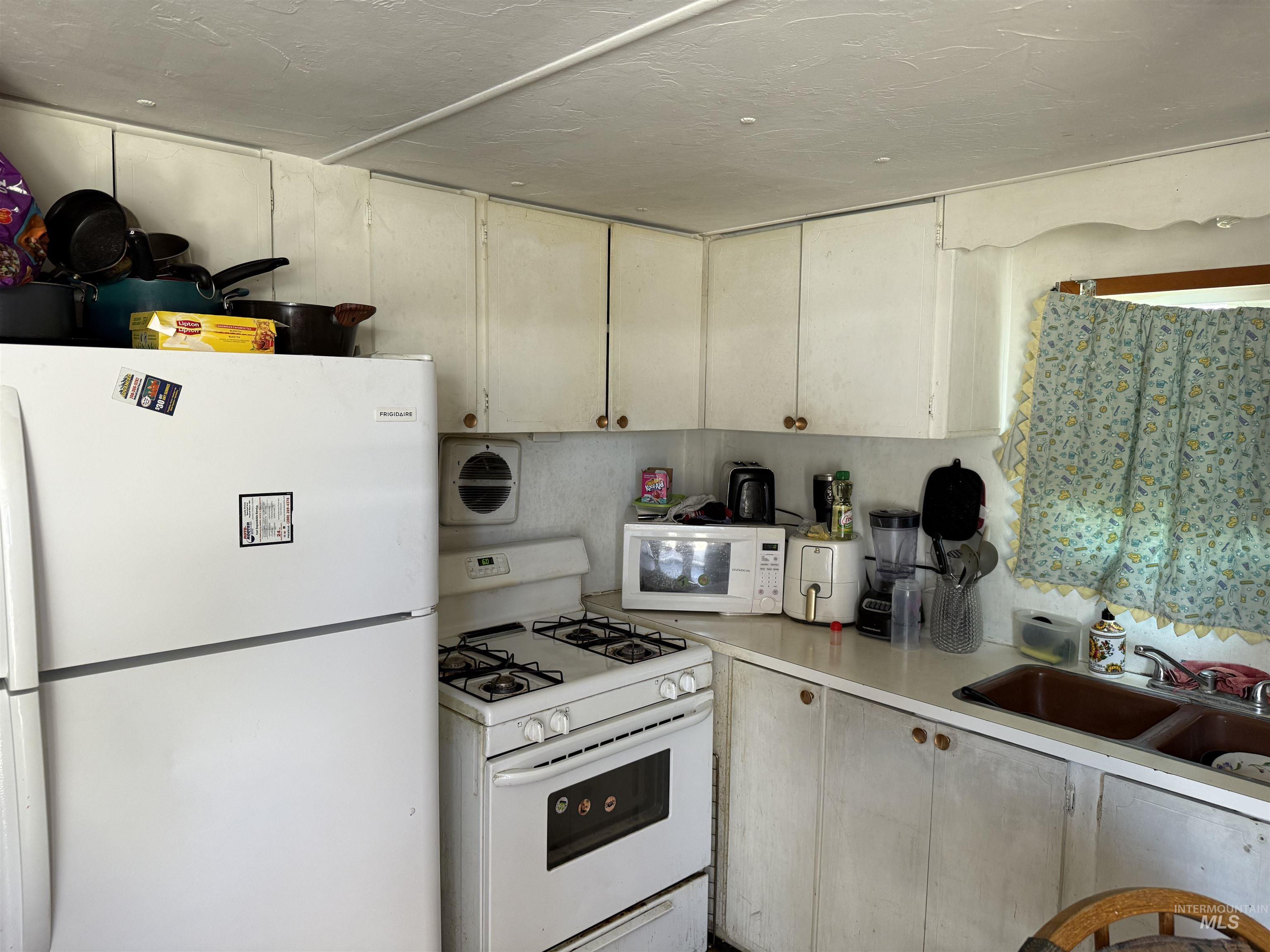 Kitchen with white appliances and light countertops