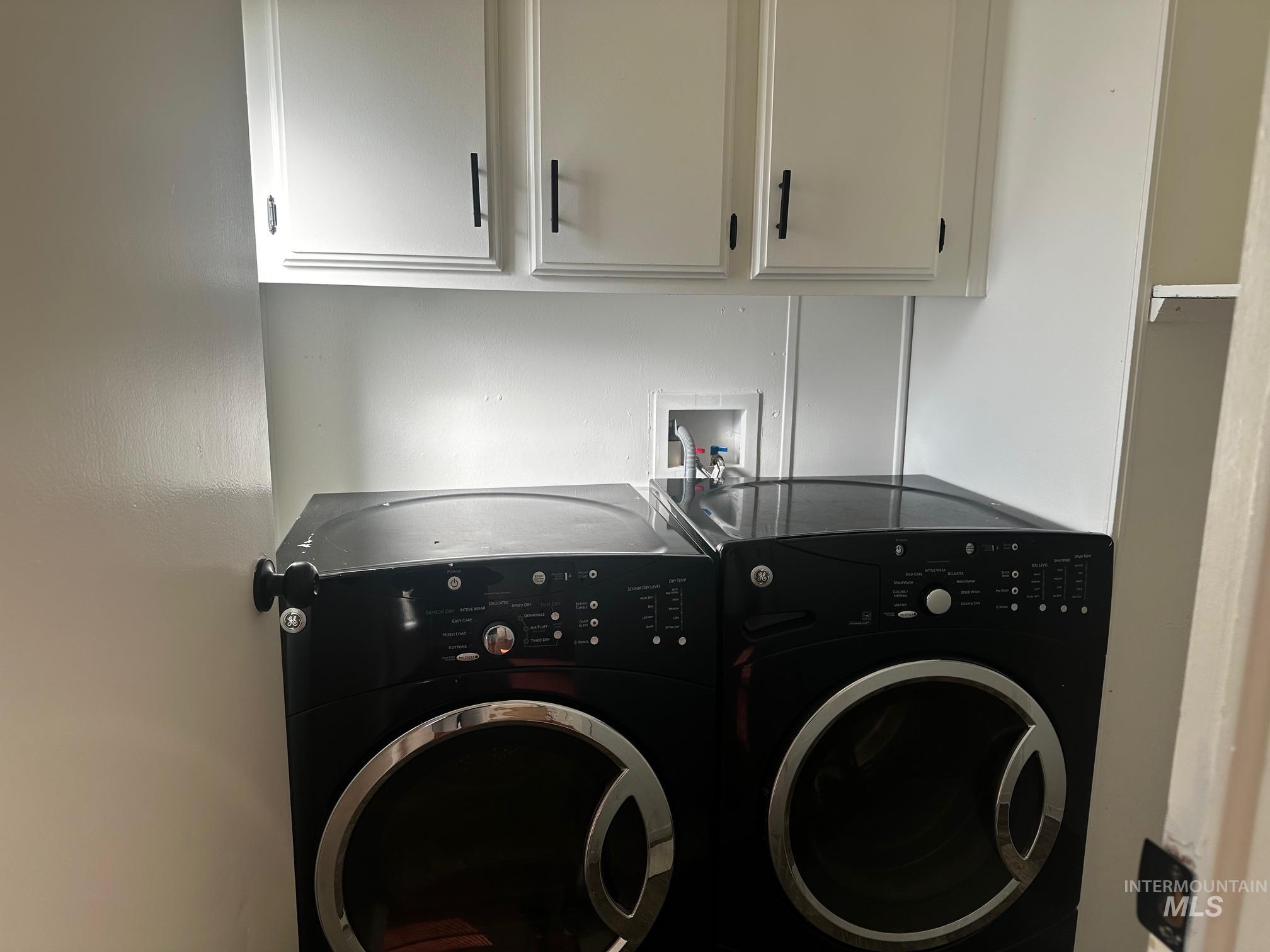 Washroom with cabinet space and independent washer and dryer
