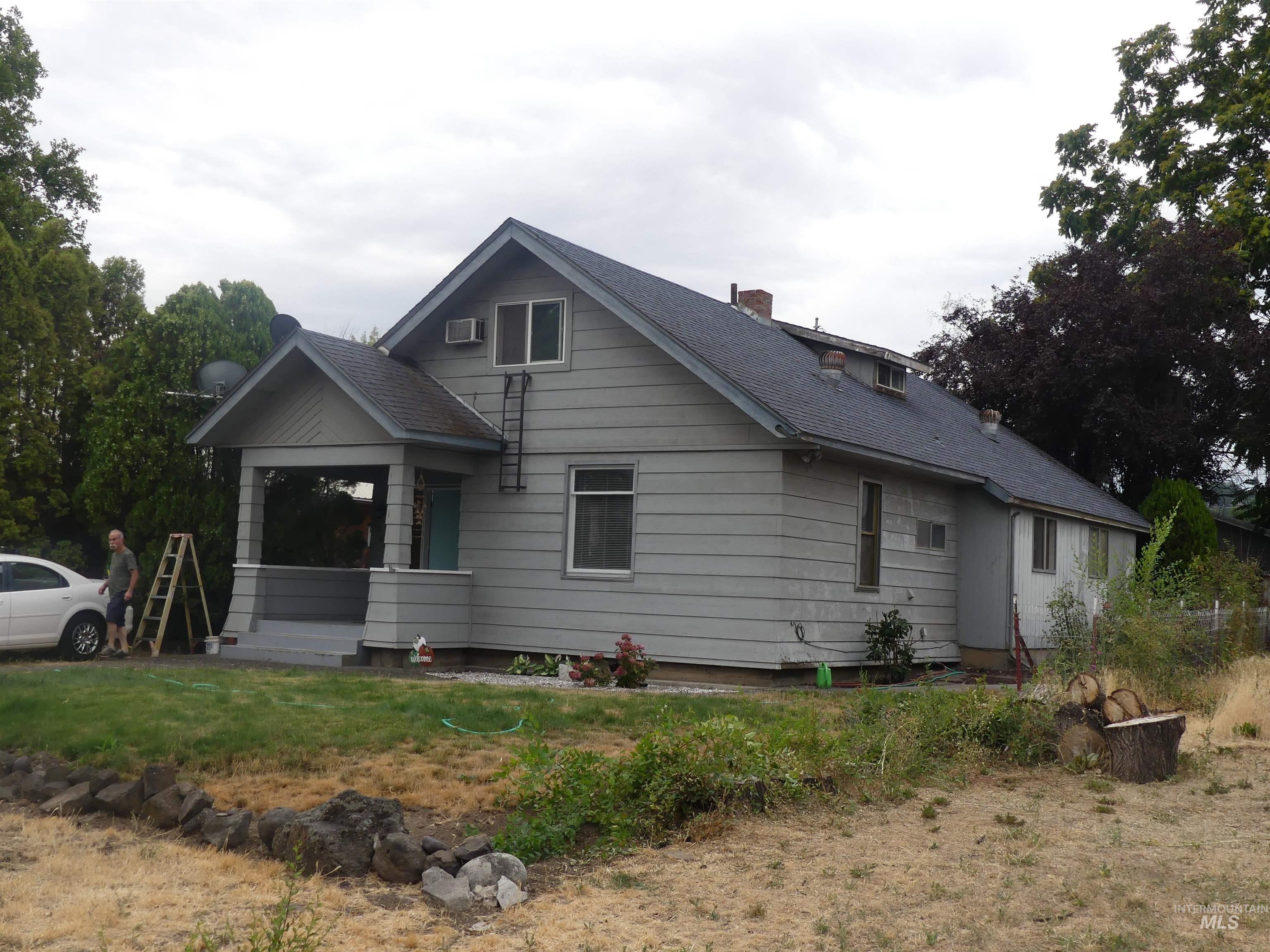 View of front of home with a chimney and roof with shingles