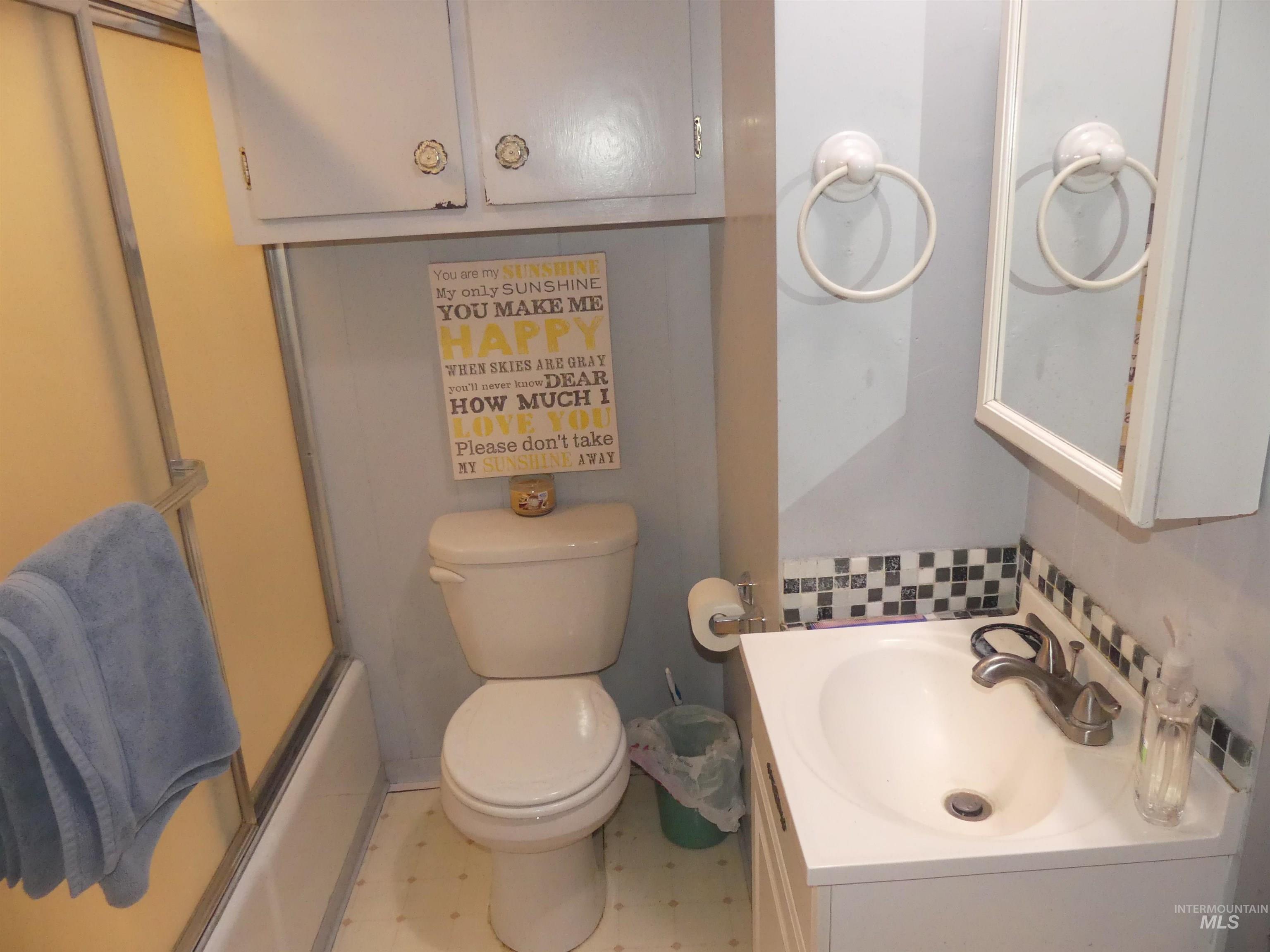Bathroom with vanity, tile patterned floors, and combined bath / shower with glass door