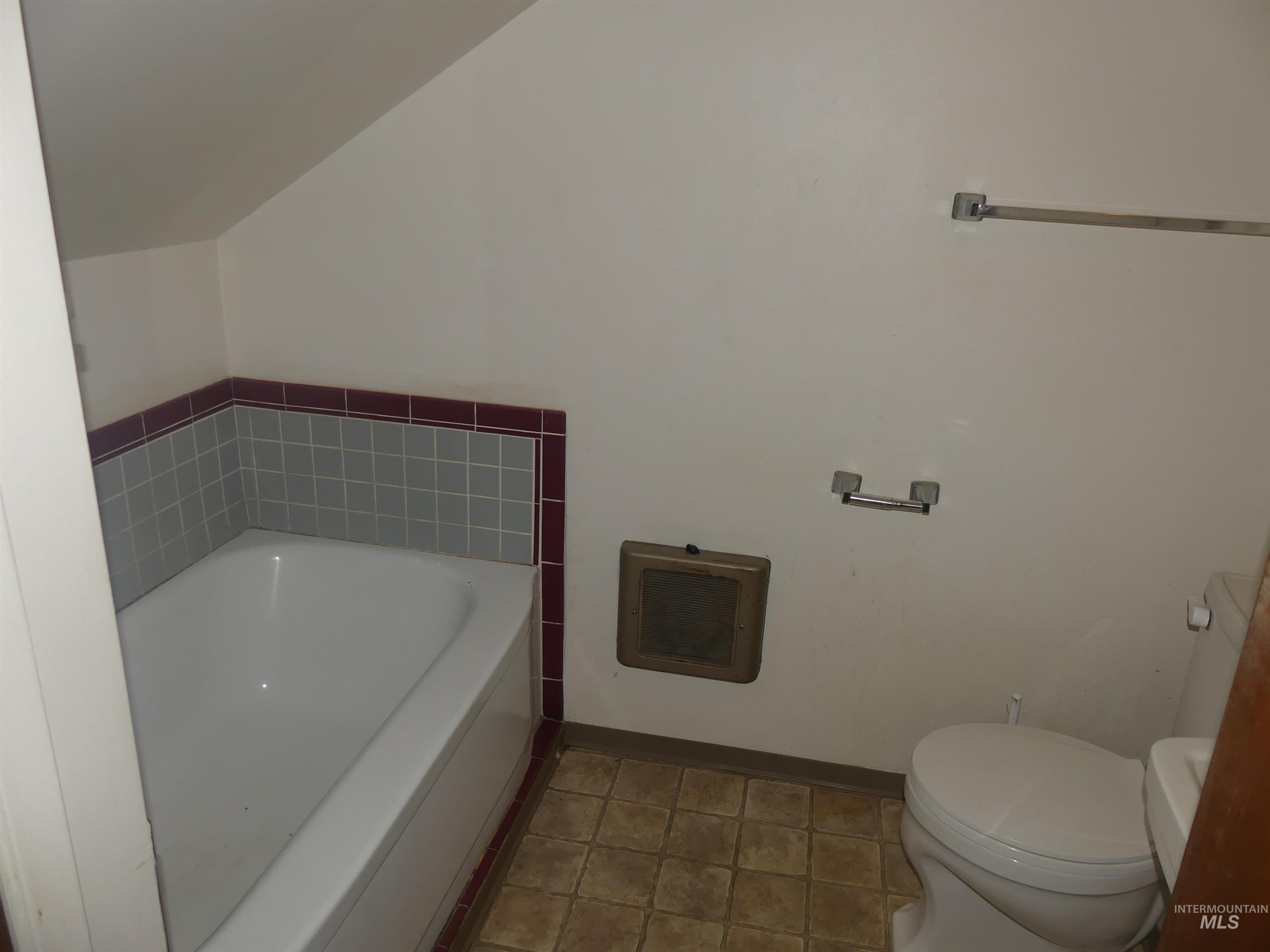 Bathroom featuring a garden tub and tile patterned flooring