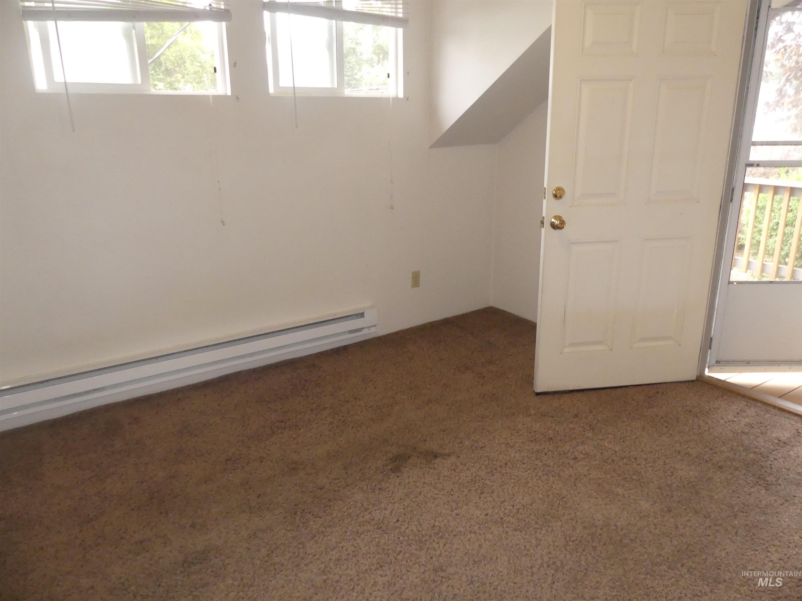 Carpeted entryway featuring a baseboard heating unit