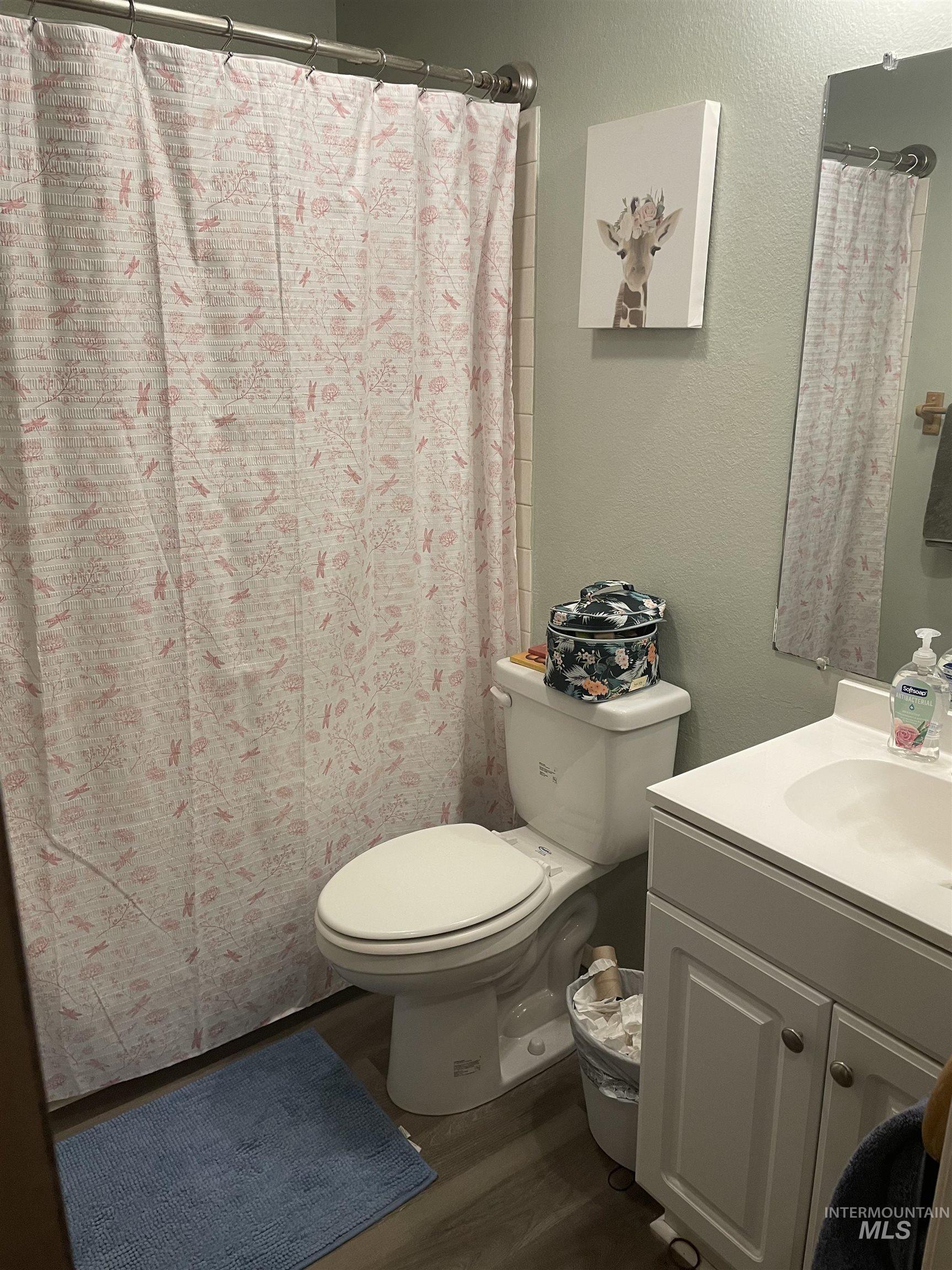 Bathroom featuring wood finished floors, a textured wall, and vanity