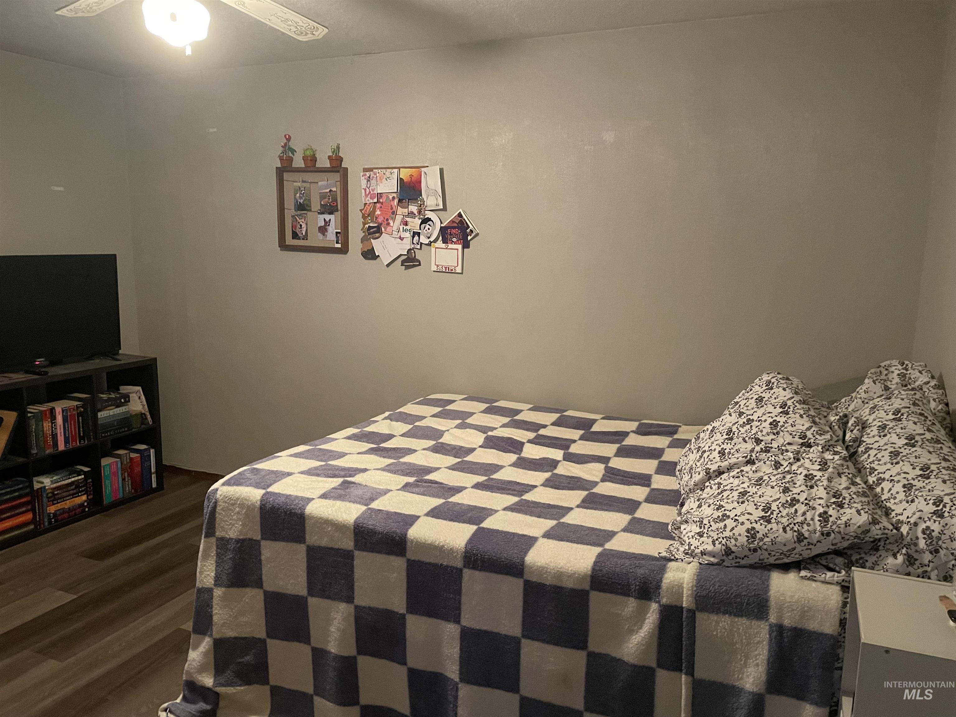 Bedroom featuring dark wood-style flooring and a ceiling fan