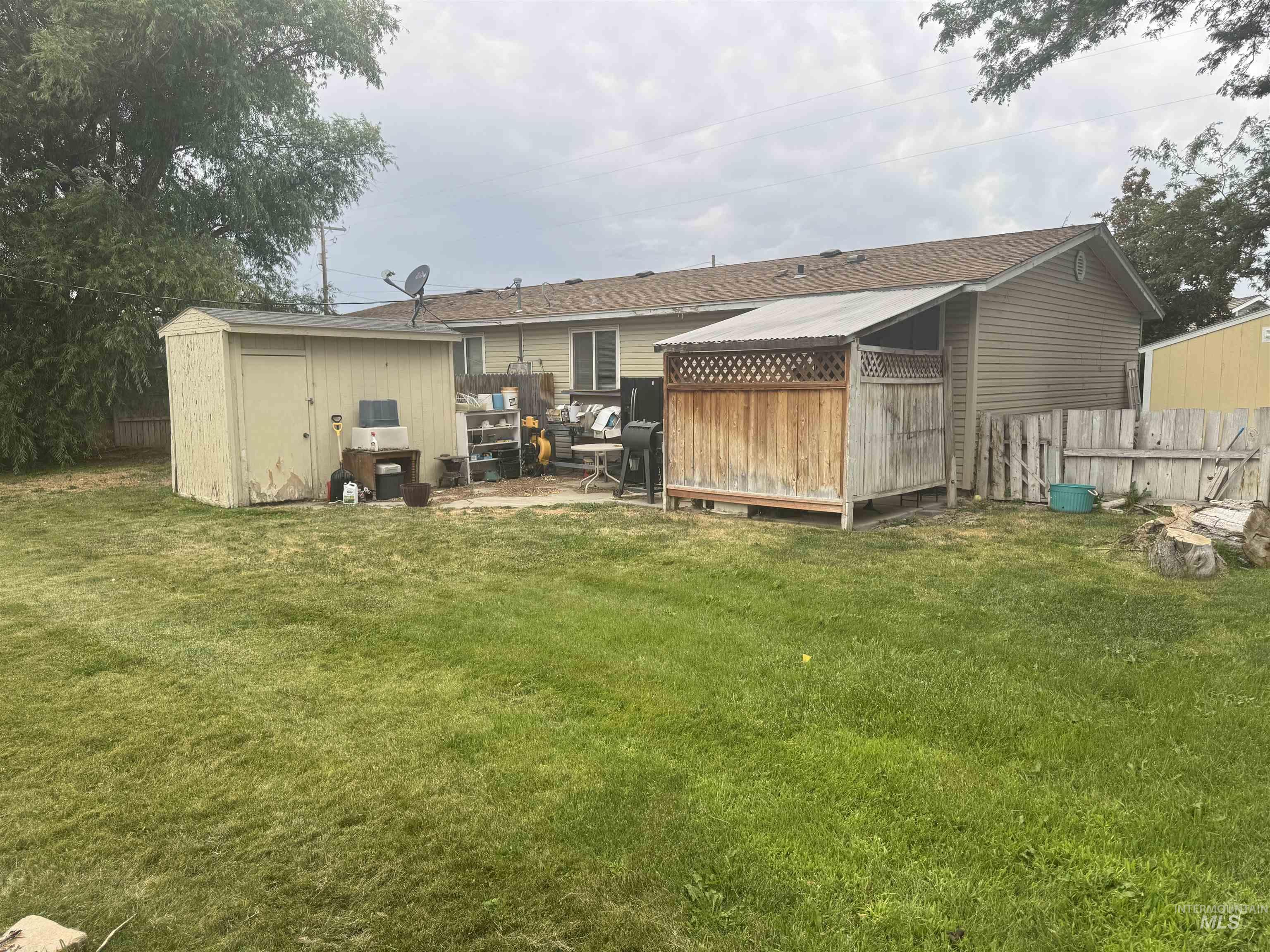 Rear view of house featuring a storage unit