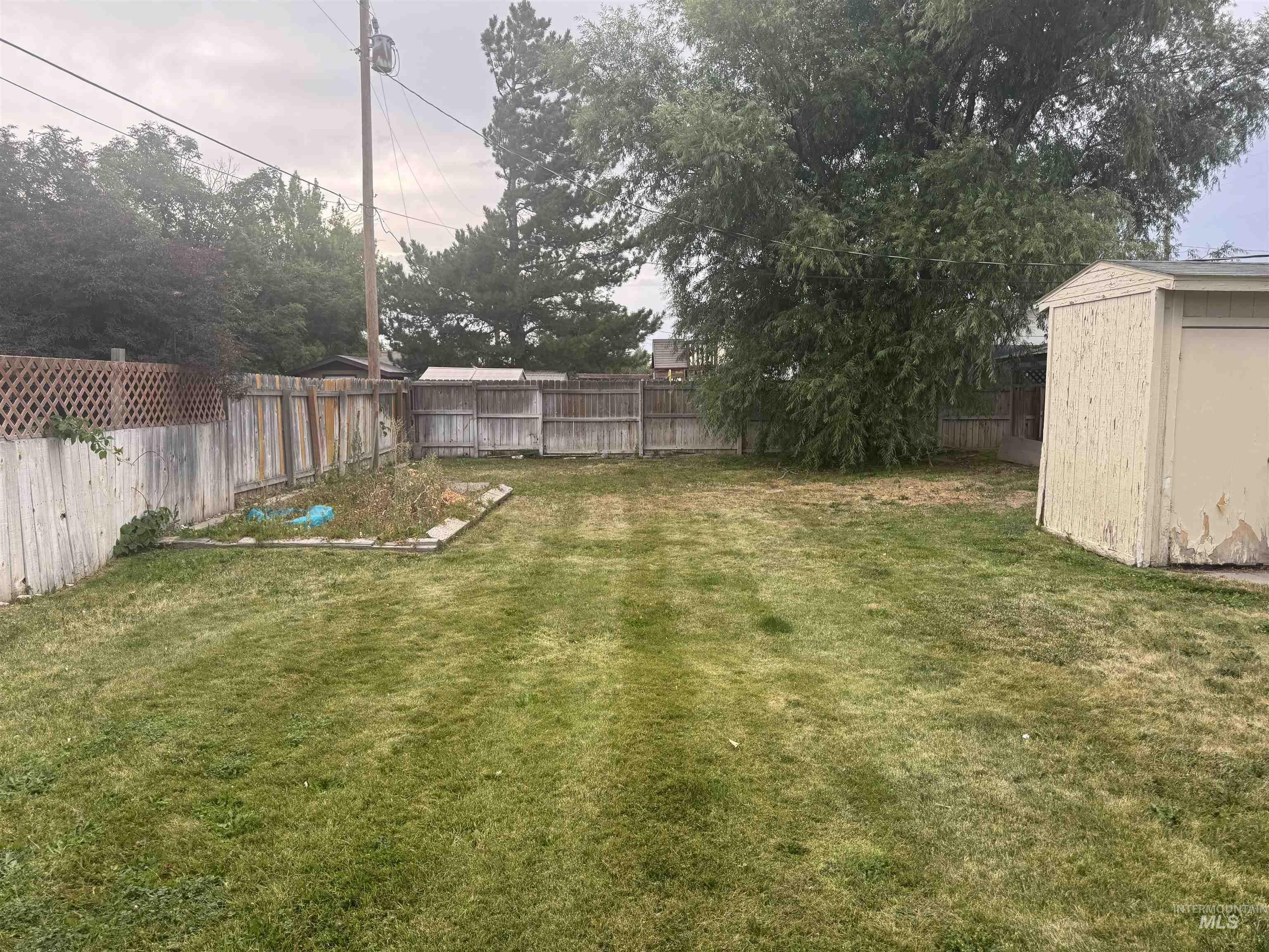 Fenced backyard with a storage unit