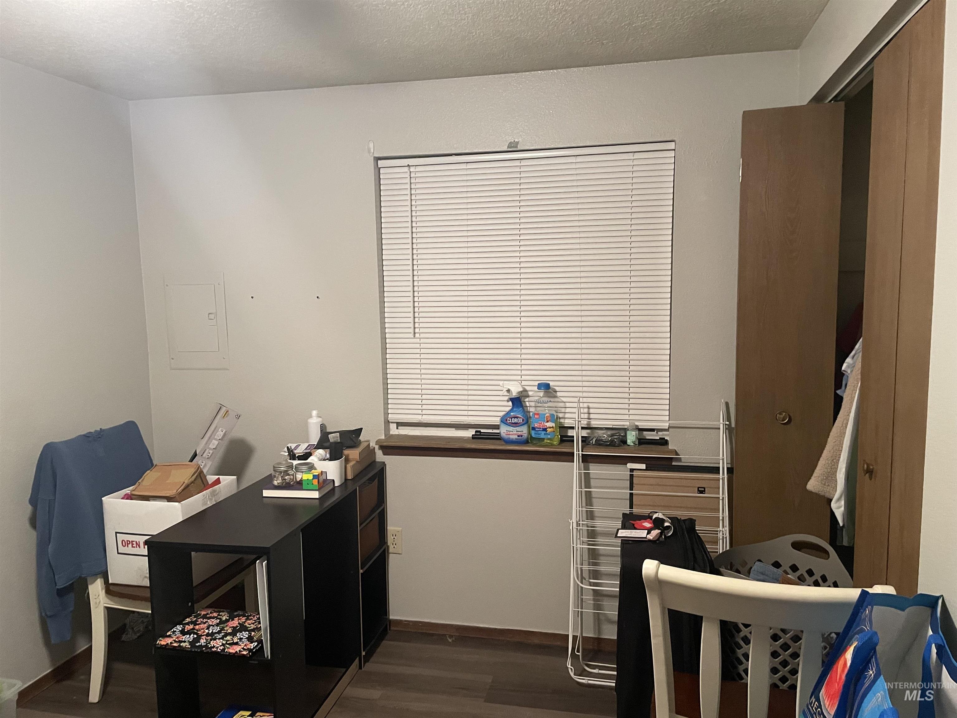 Home office featuring a textured ceiling and dark wood-style flooring