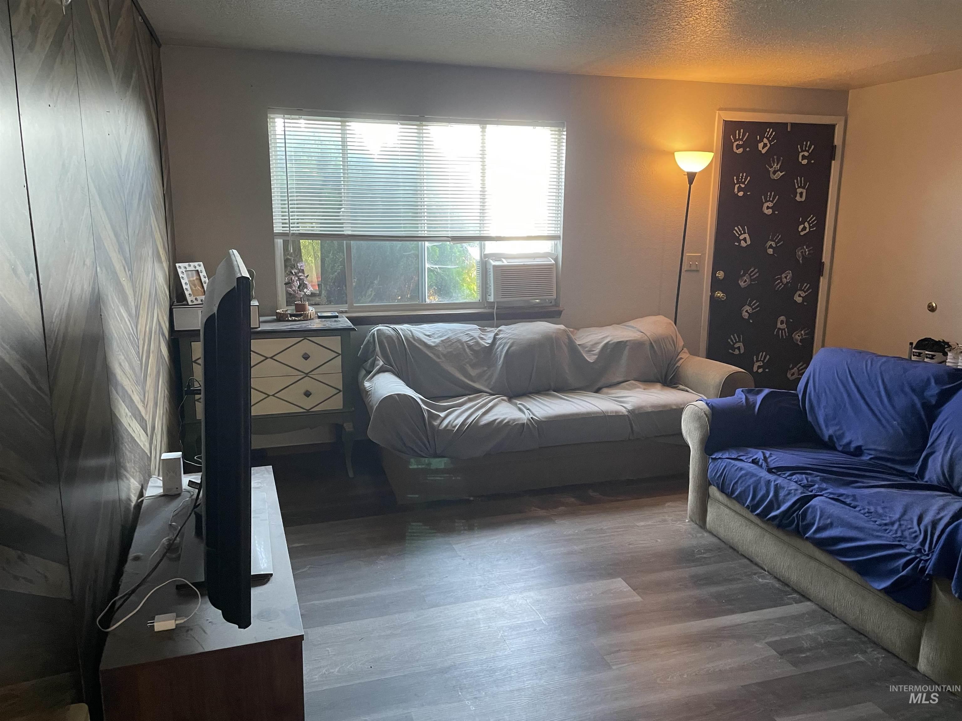 Living room with wood finished floors and a textured ceiling