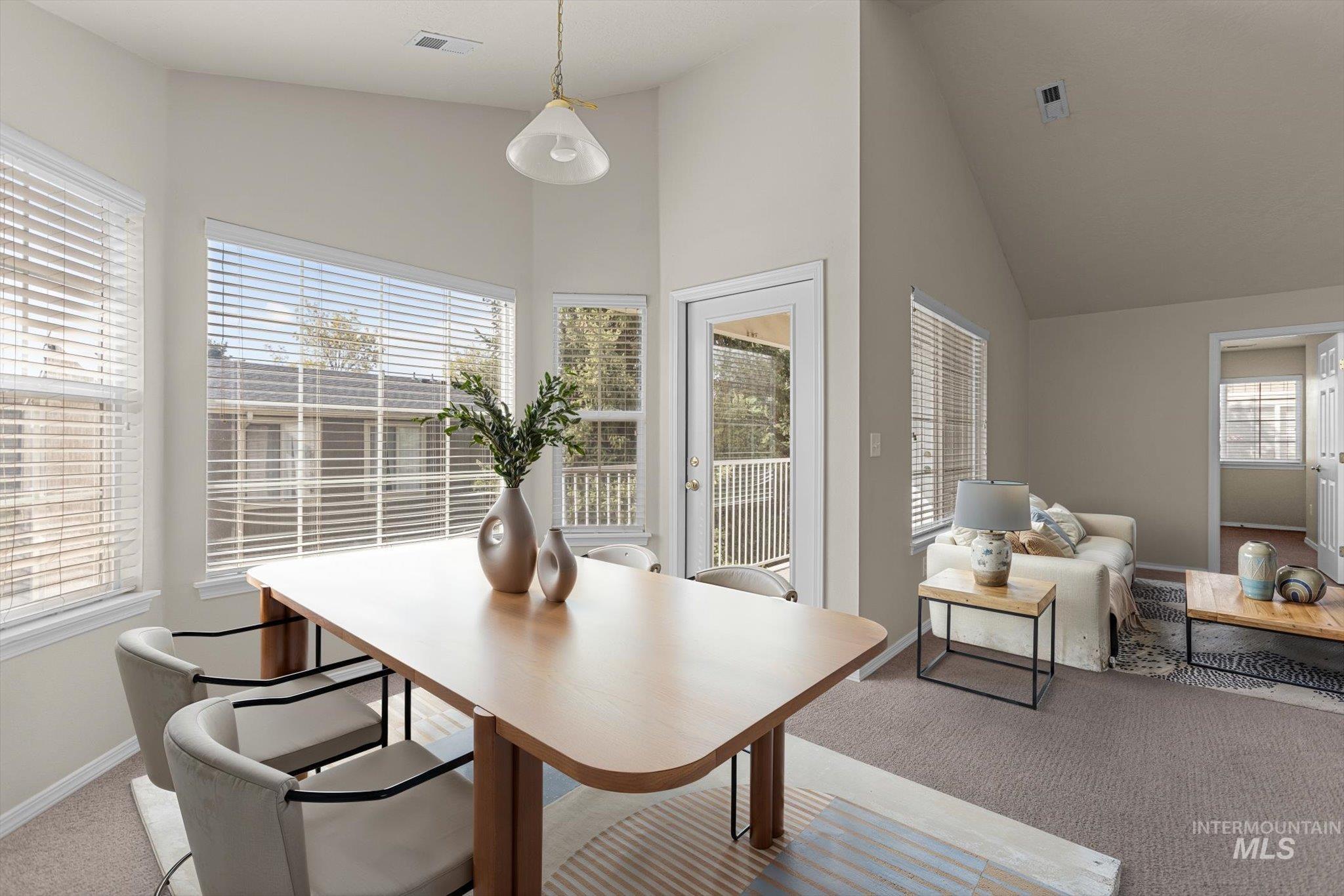 Dining area featuring carpet flooring and high vaulted ceiling