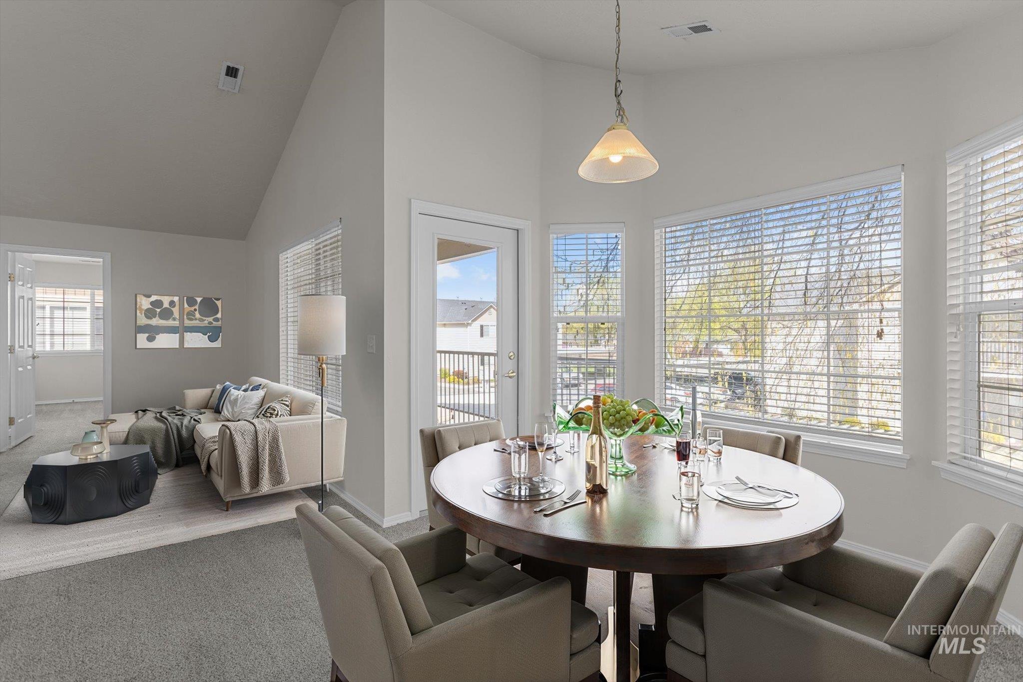 Dining room featuring high vaulted ceiling and carpet