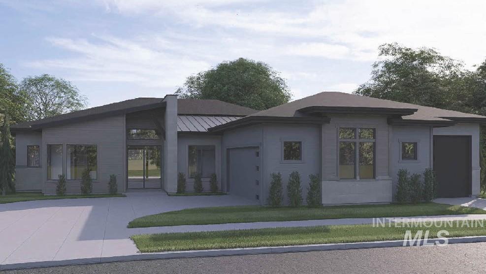 View of front of home with a standing seam roof, a garage, a metal roof, a front lawn, and driveway