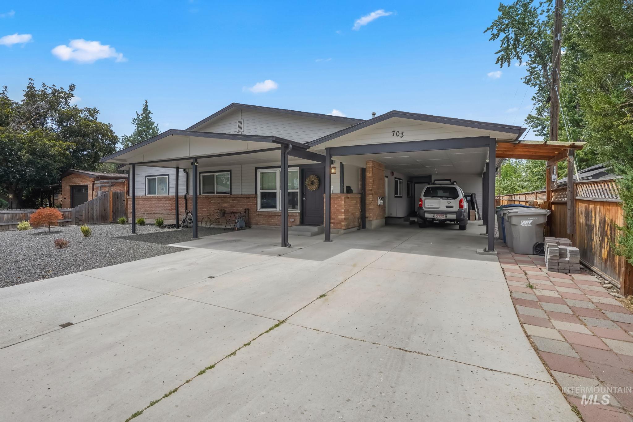 Ranch-style house featuring brick siding, an attached carport, and concrete driveway