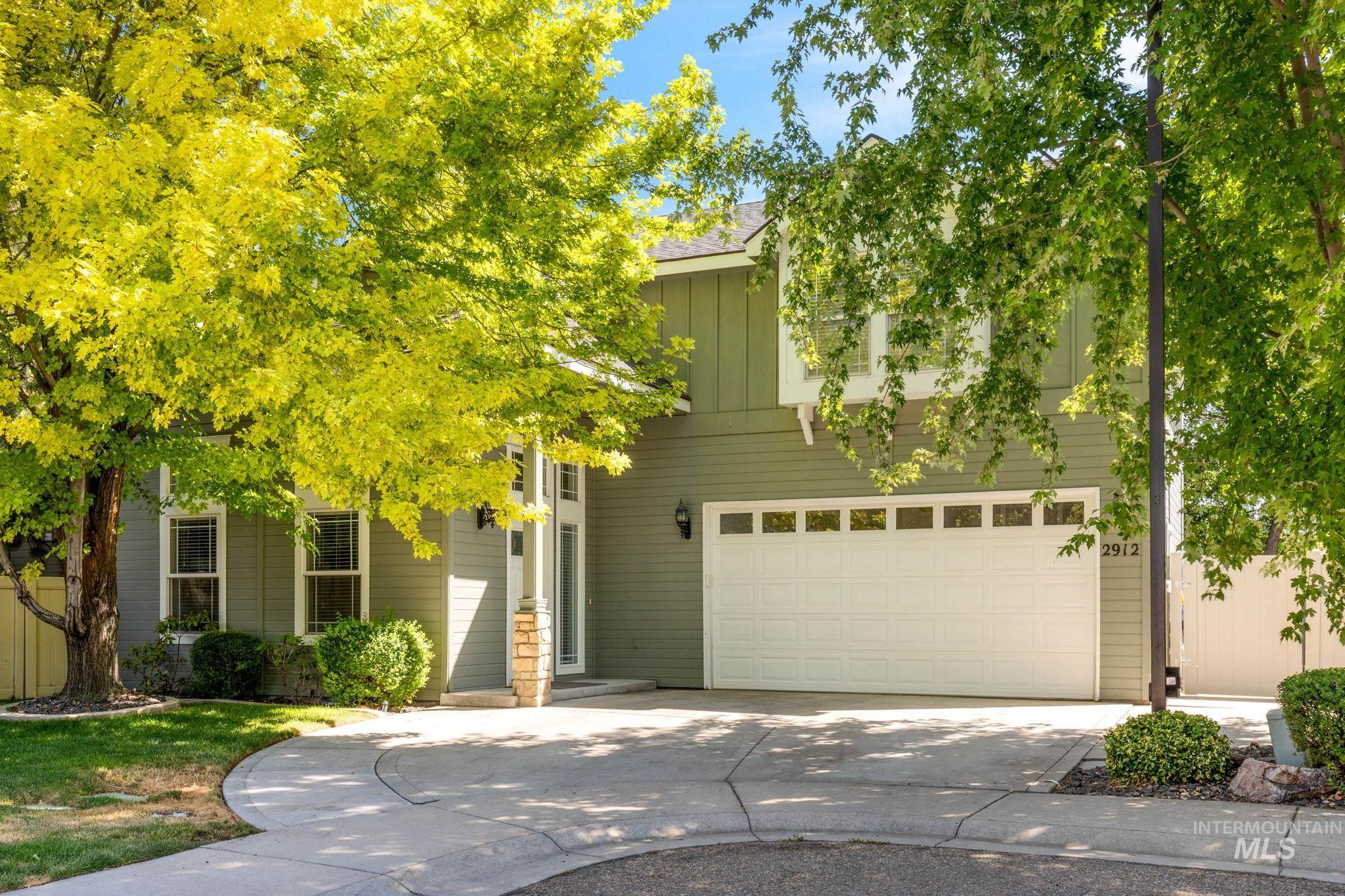 Obstructed view of property with an attached garage and concrete driveway