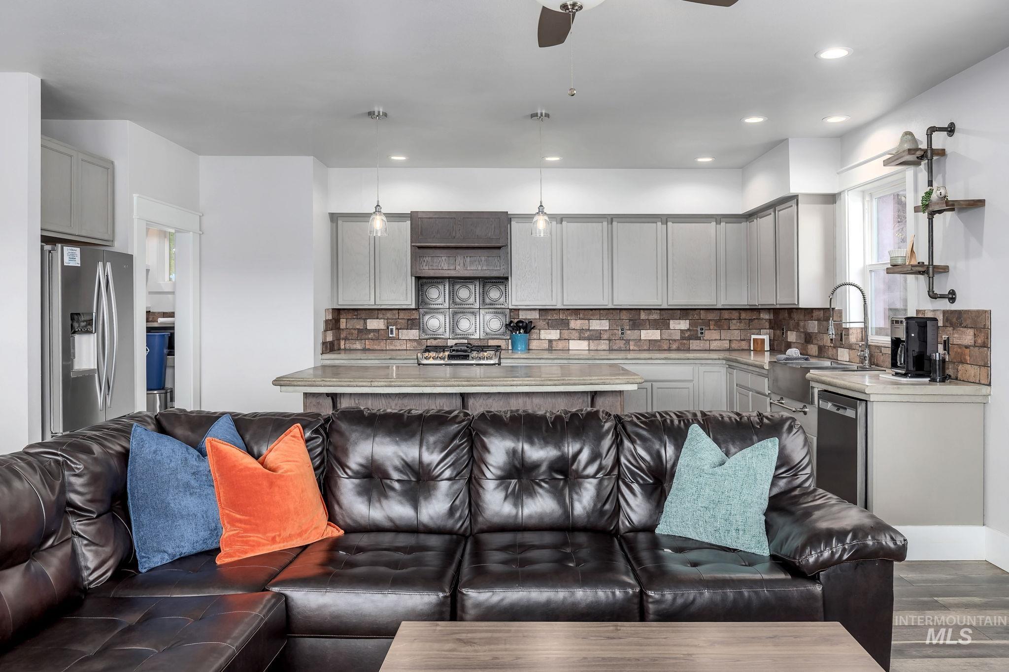 Living room featuring a ceiling fan, dark wood-style flooring, and recessed lighting