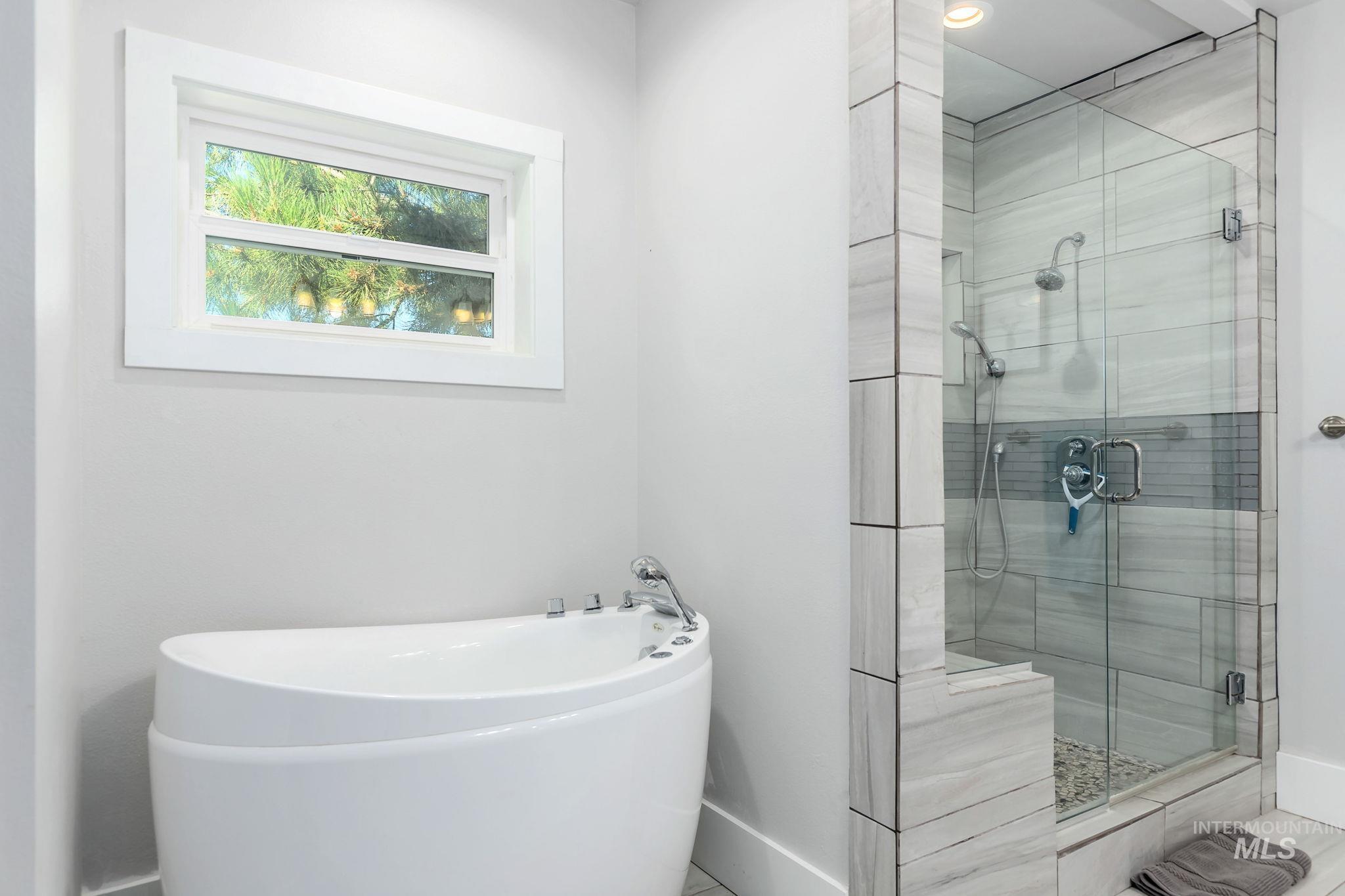 Bathroom with a freestanding bath and a shower stall