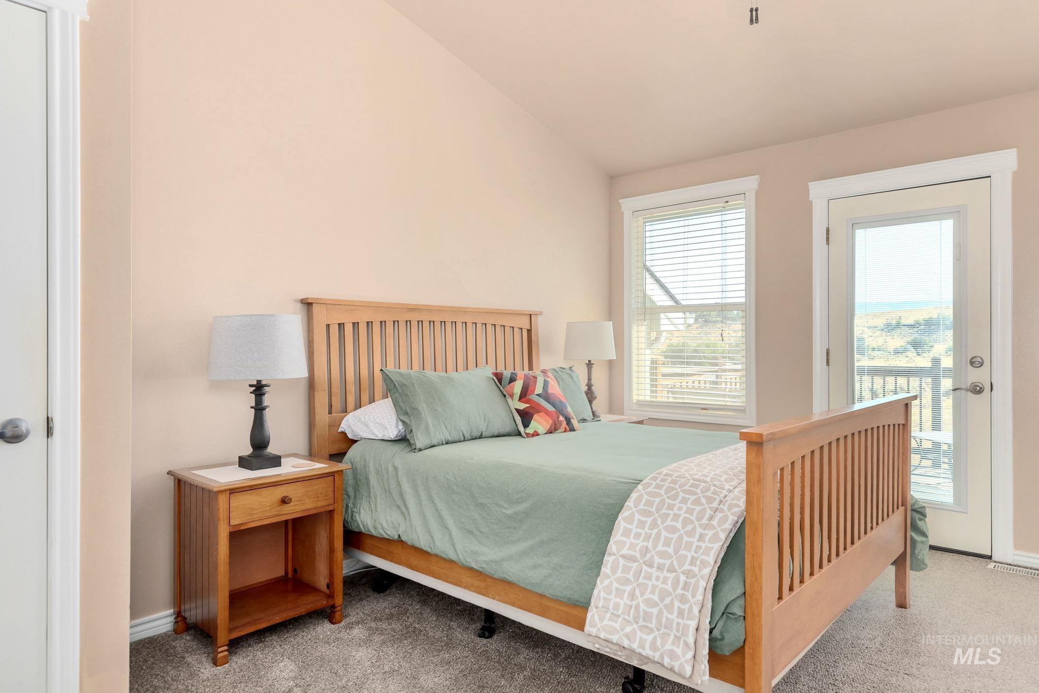 Carpeted bedroom with access to outside and lofted ceiling