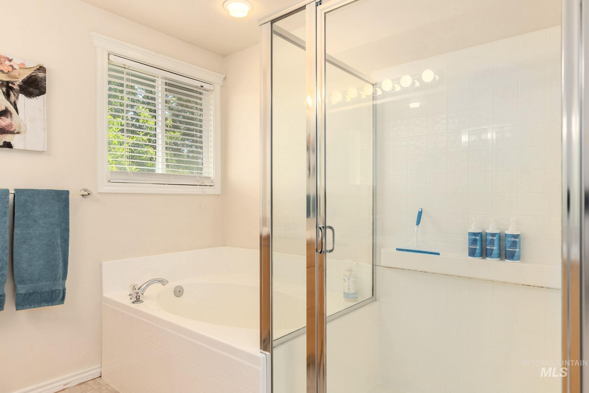 Bathroom with a shower stall and a bath
