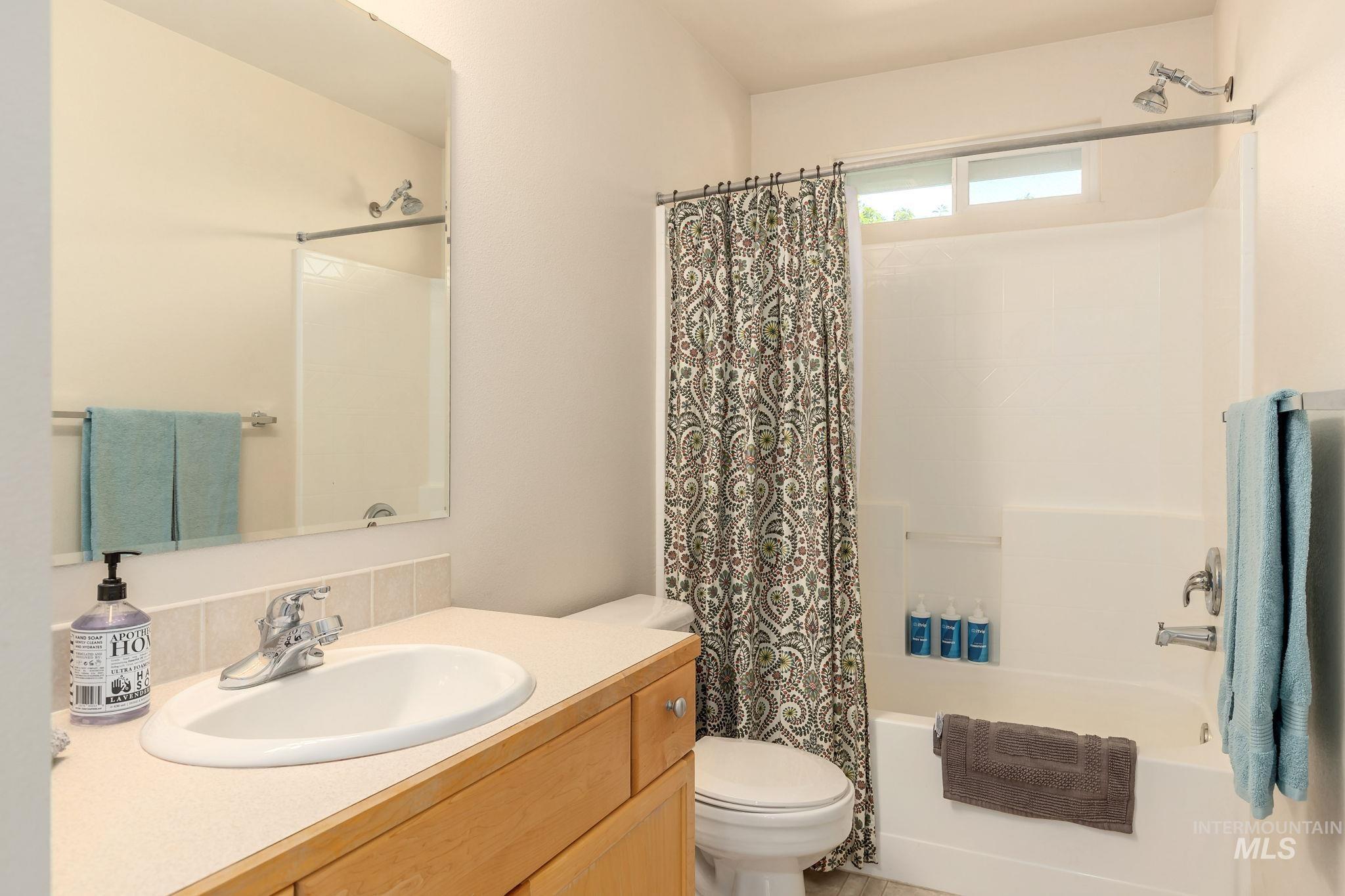 Full bath featuring vanity and shower / bath combo with shower curtain