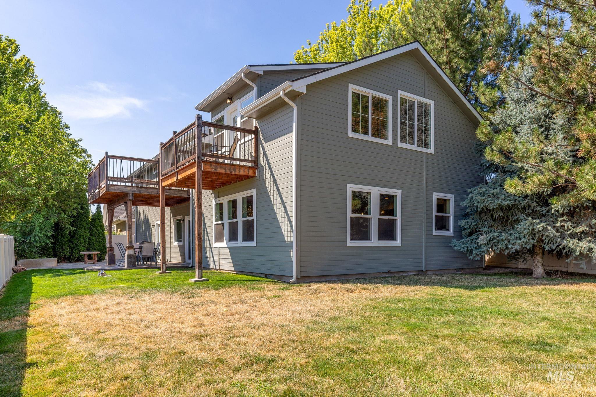 Back of house with a wooden deck and a lawn