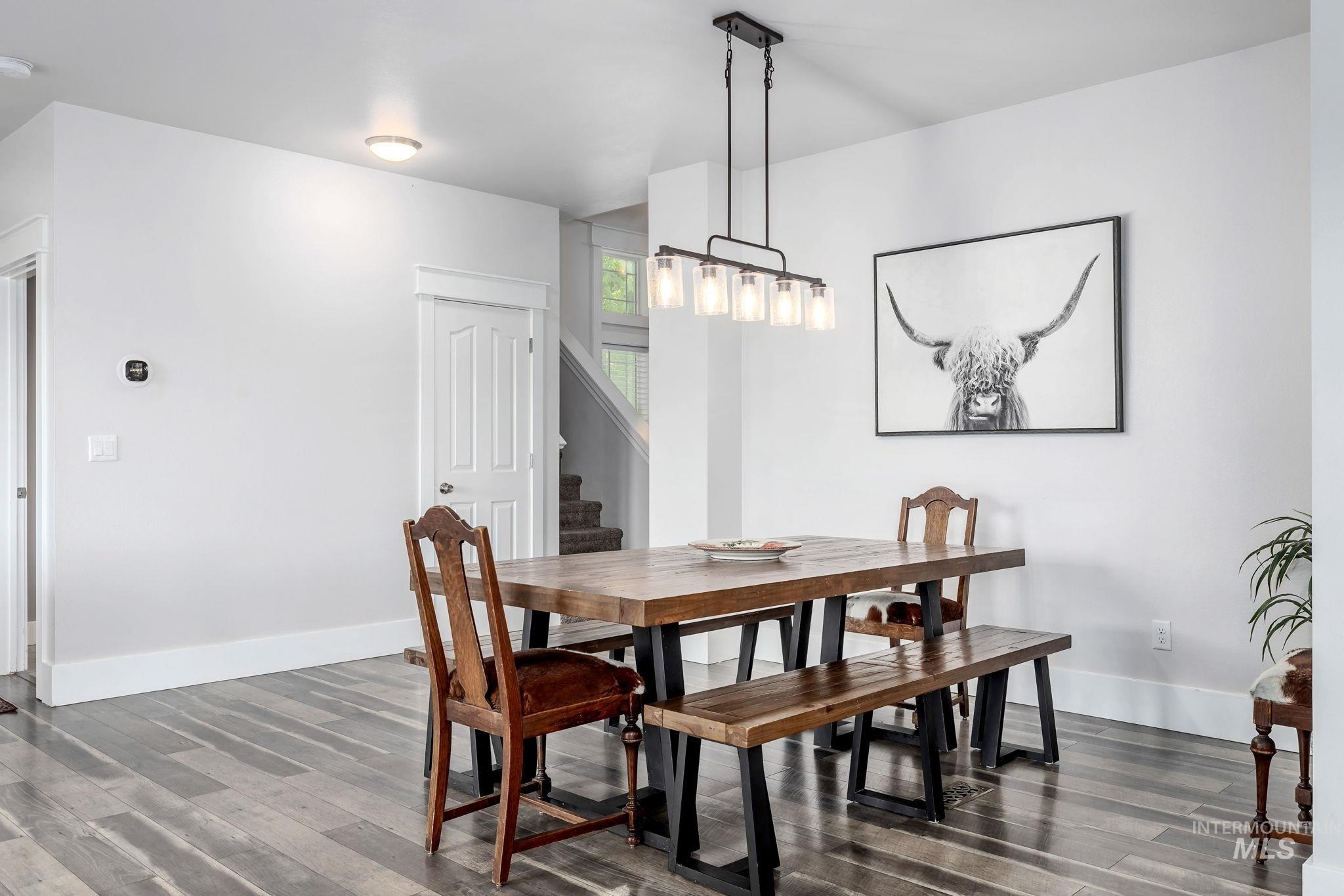 Dining room featuring stairs and dark wood-type flooring