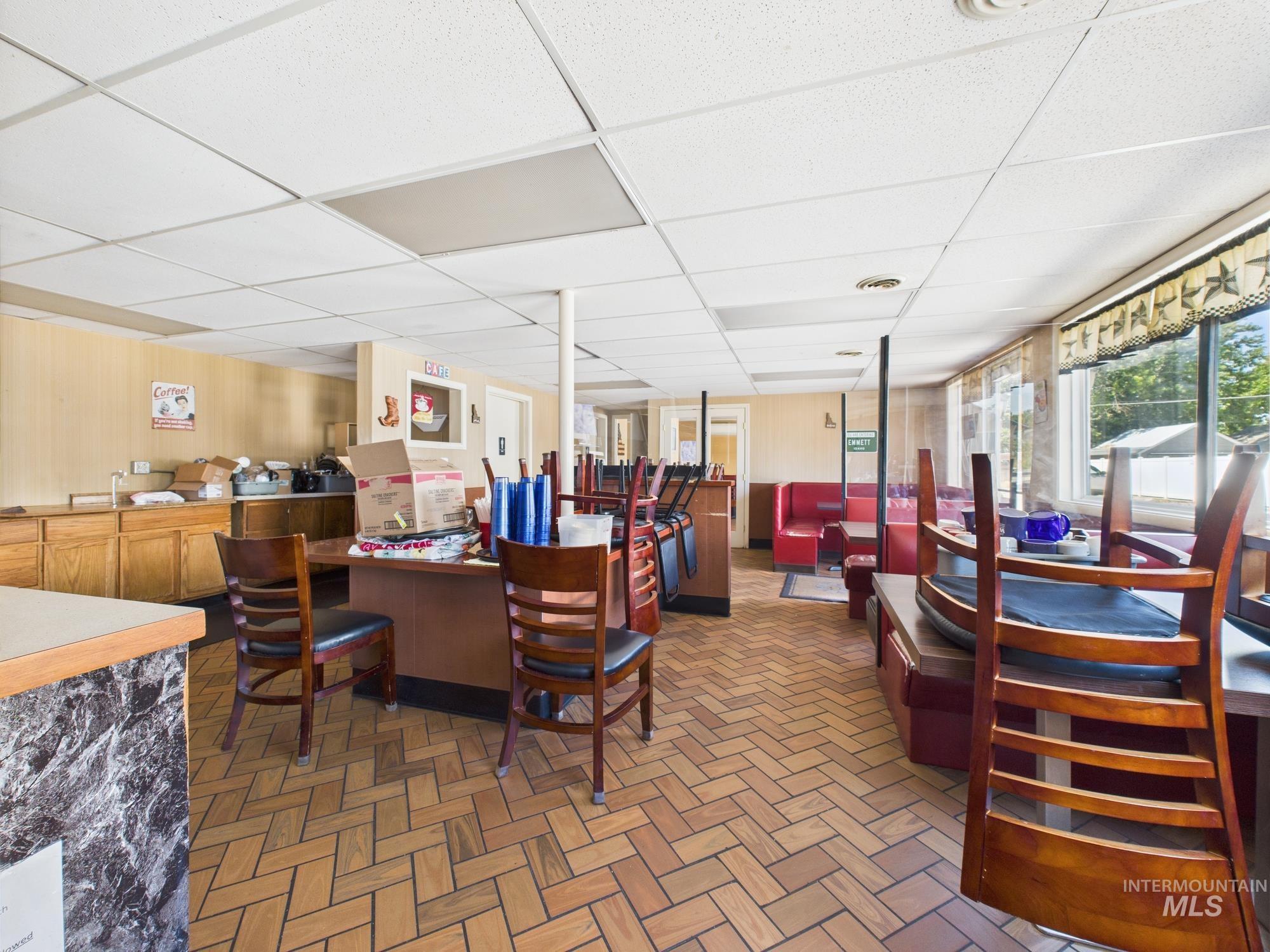 Dining room featuring a drop ceiling, healthy amount of natural light, and a bar