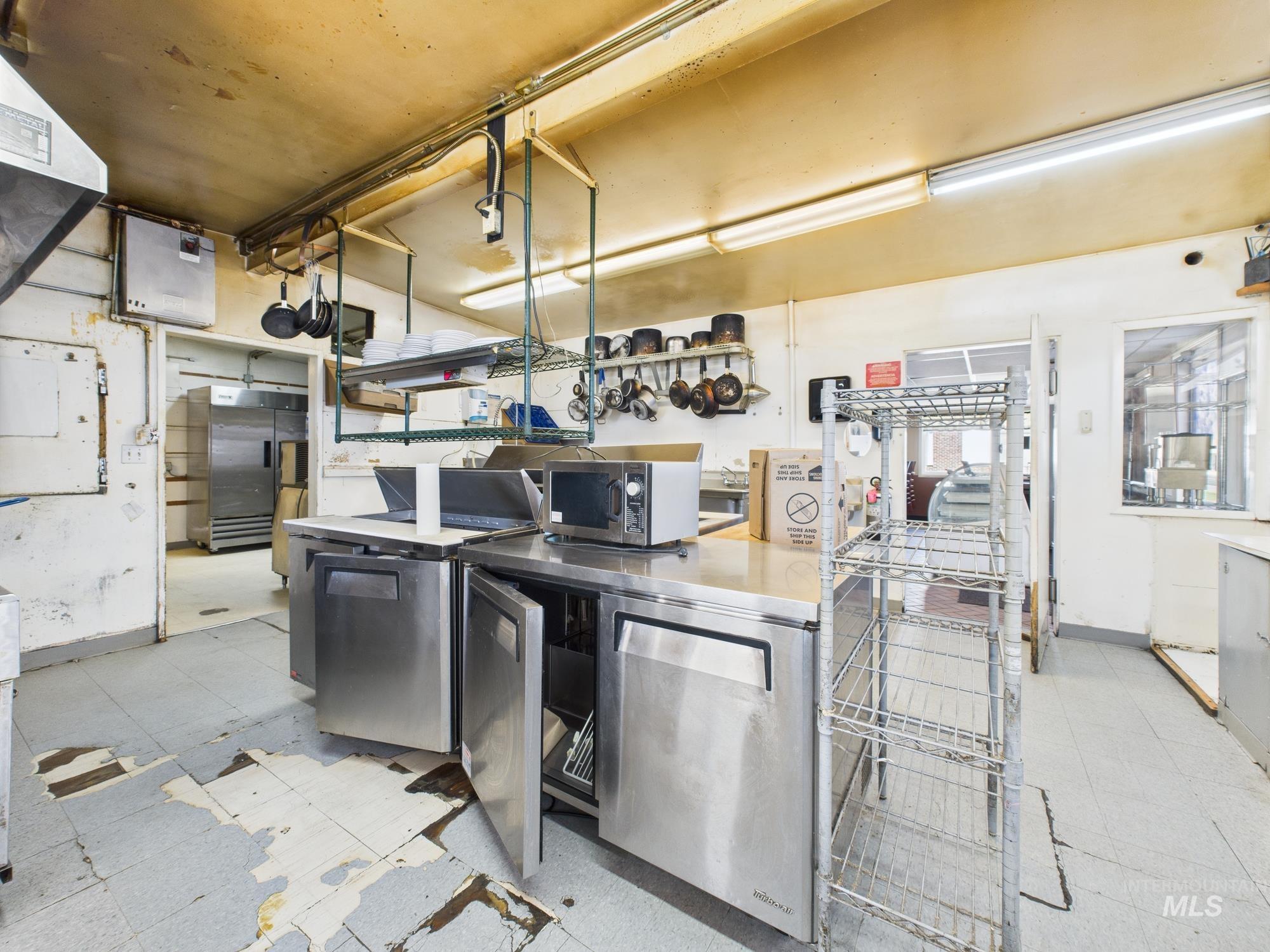 Kitchen featuring stainless steel microwave, tile patterned floors, washer / dryer, and refrigerator