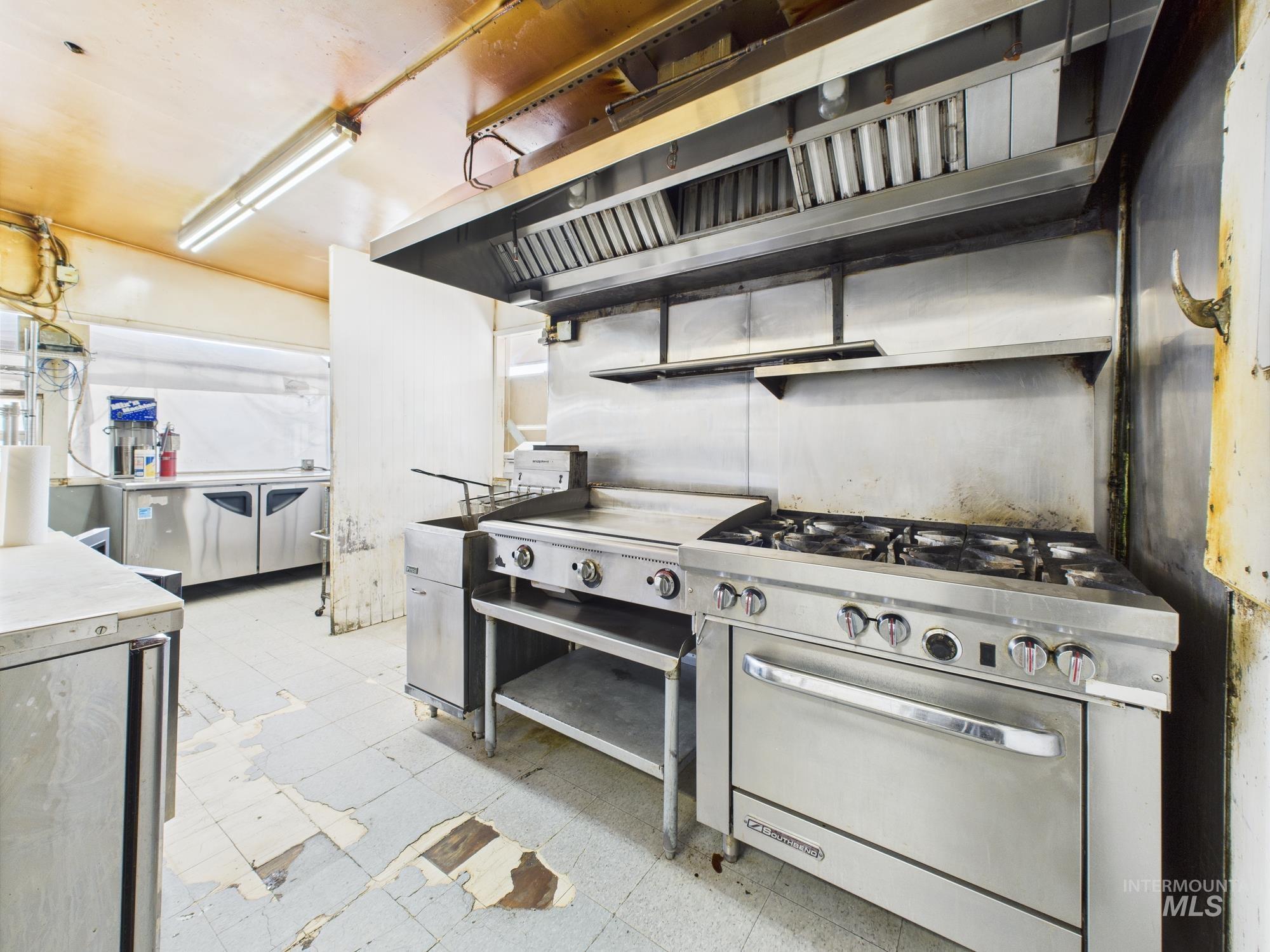Kitchen with wall chimney exhaust hood, designer range, and range